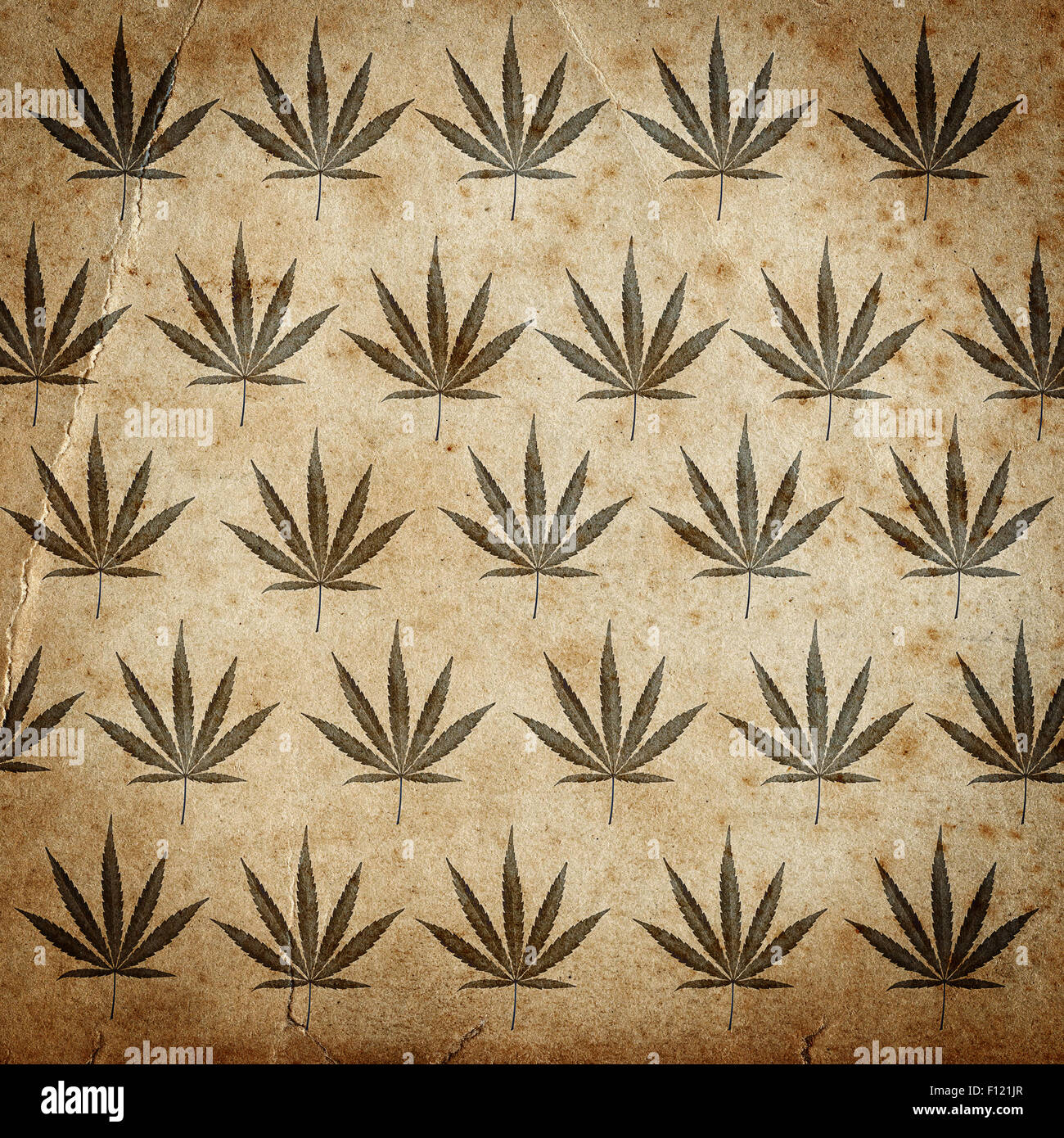 Grungy old paper background with cannabis leaves Stock Photo