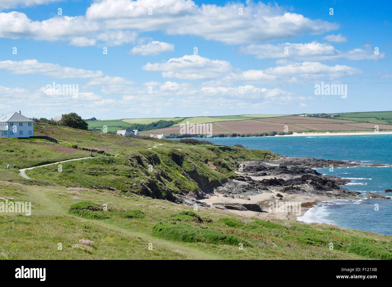 North Cornwall - on the coast path above Greenaway Beach - river Camel estuary + Daymer Bay beyond - sunlight blue sea + sky Stock Photo