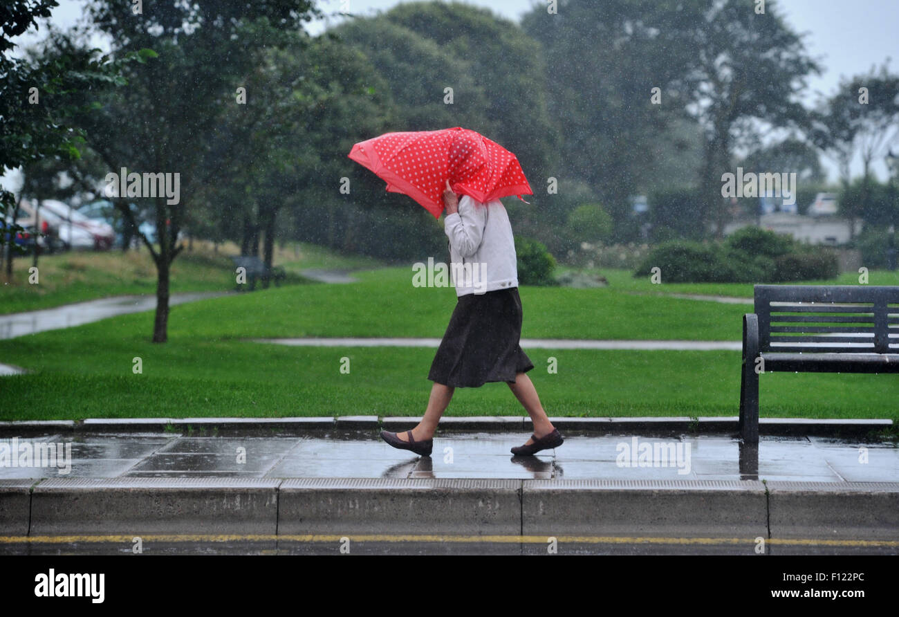 Brighton, UK. 25th August, 2015. This lady has a makeshift umbrella as she gets caught in a torrential downpour of rain today in the centre of Brighton and Hove . The dreadful summer weather is set to continue until the end of the week in the UK  Credit:  Simon Dack/Alamy Live News Stock Photo