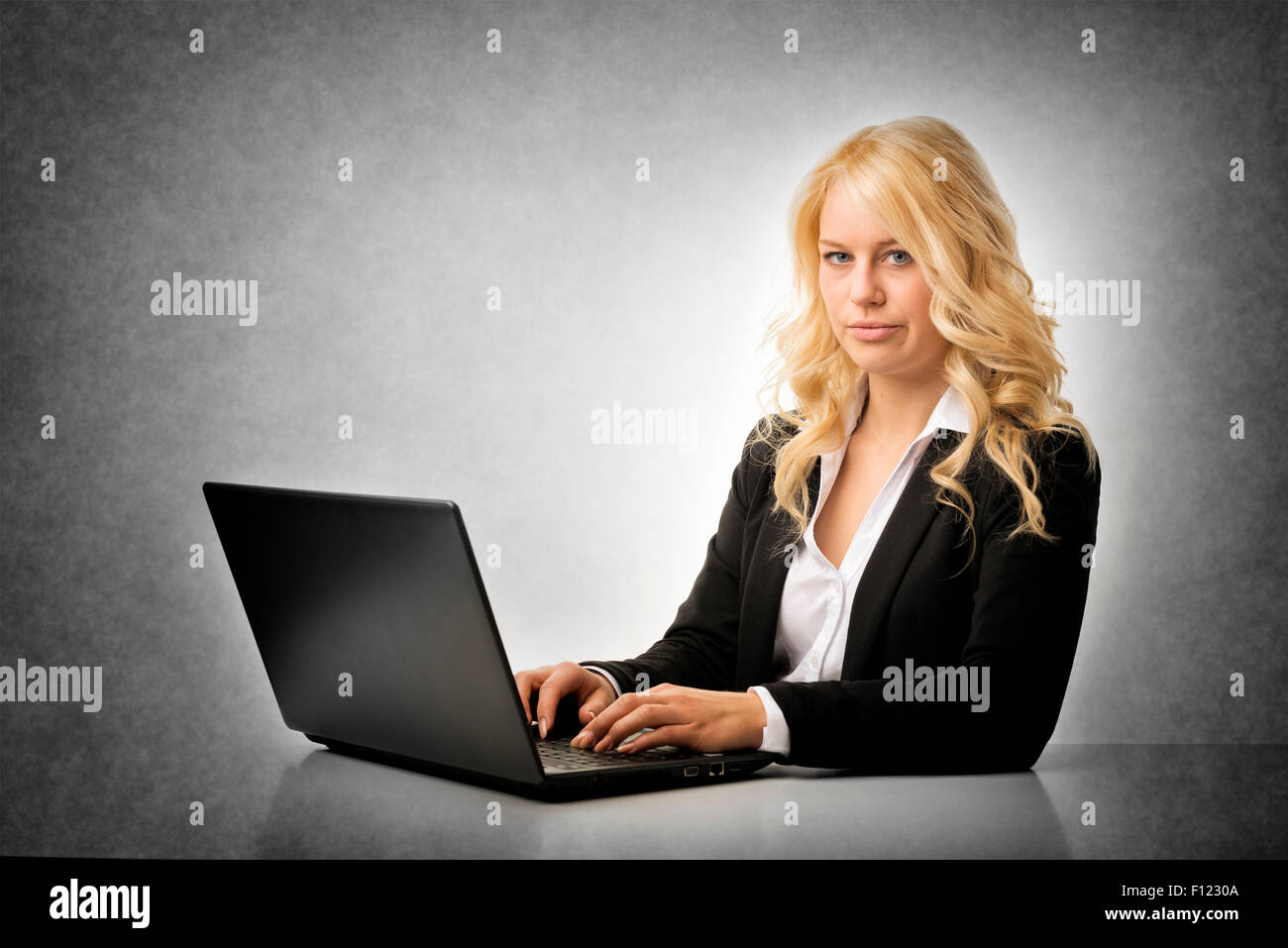 Blond business woman working frustrated on laptop Stock Photo