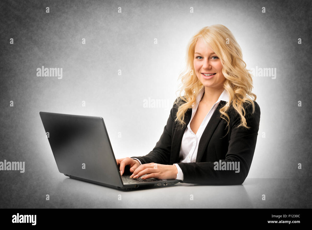 Blond happy business woman working on laptop Stock Photo - Alamy