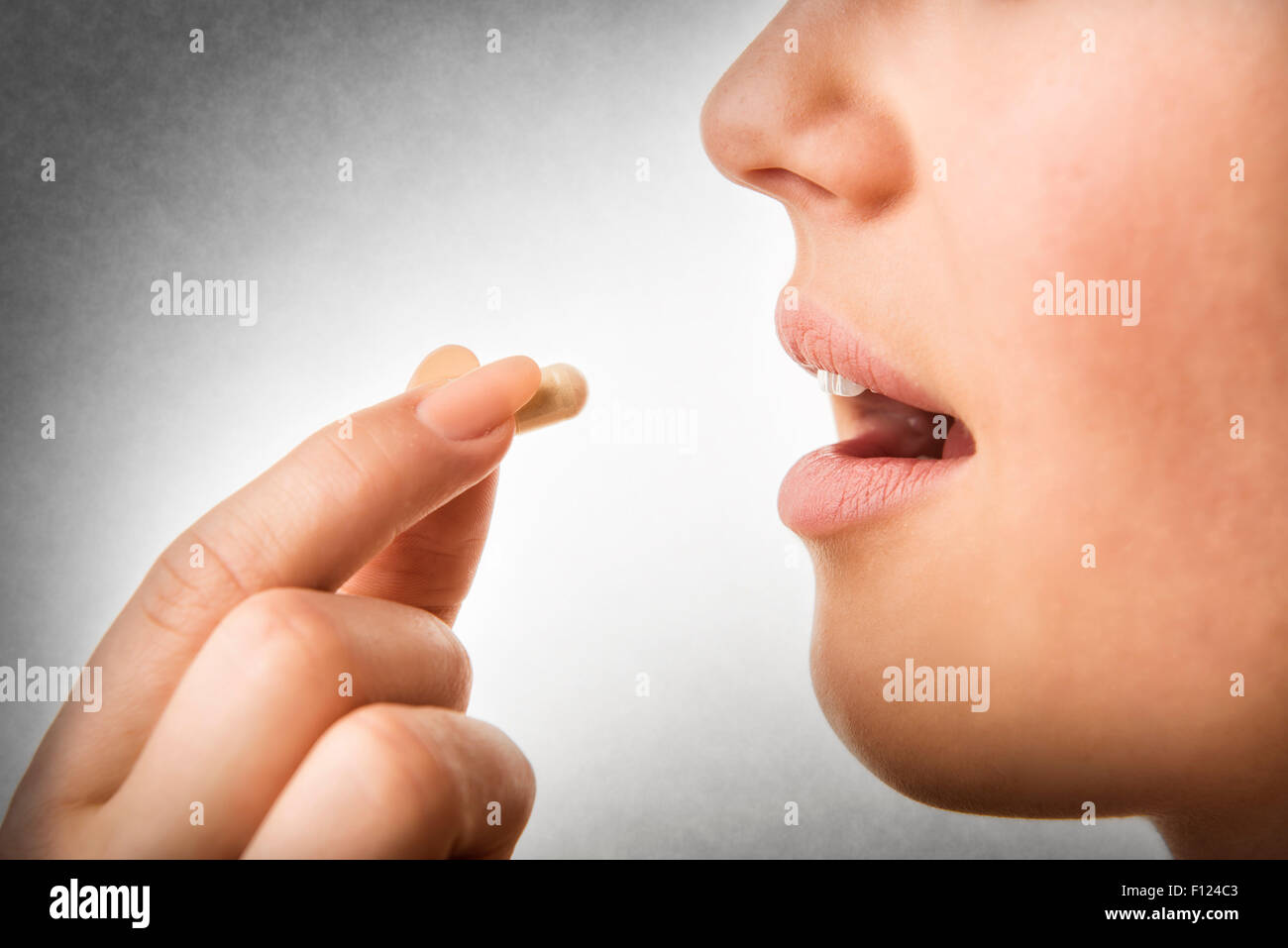 Closeup of woman taking pill Stock Photo