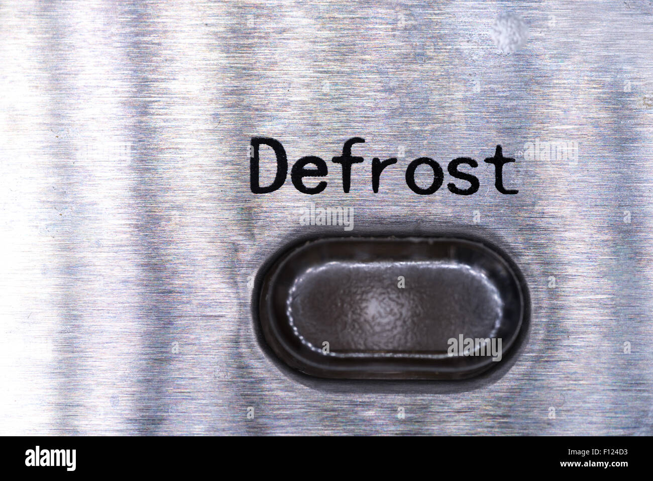 A closeup picture of a defrost button on a metalic background Stock