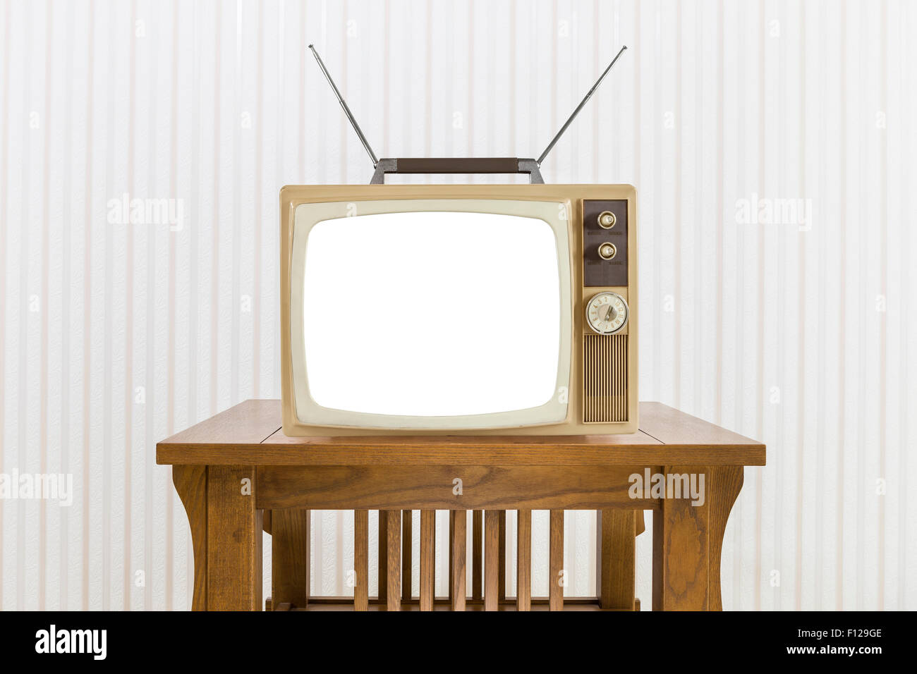 Old television with antenna on wood table with cut out screen. Stock Photo