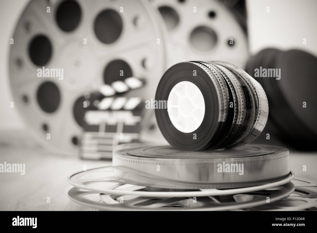 https://c8.alamy.com/comp/F12D6R/heap-of-old-35-mm-movie-reels-with-out-of-focus-clapper-and-boxes-F12D6R.jpg