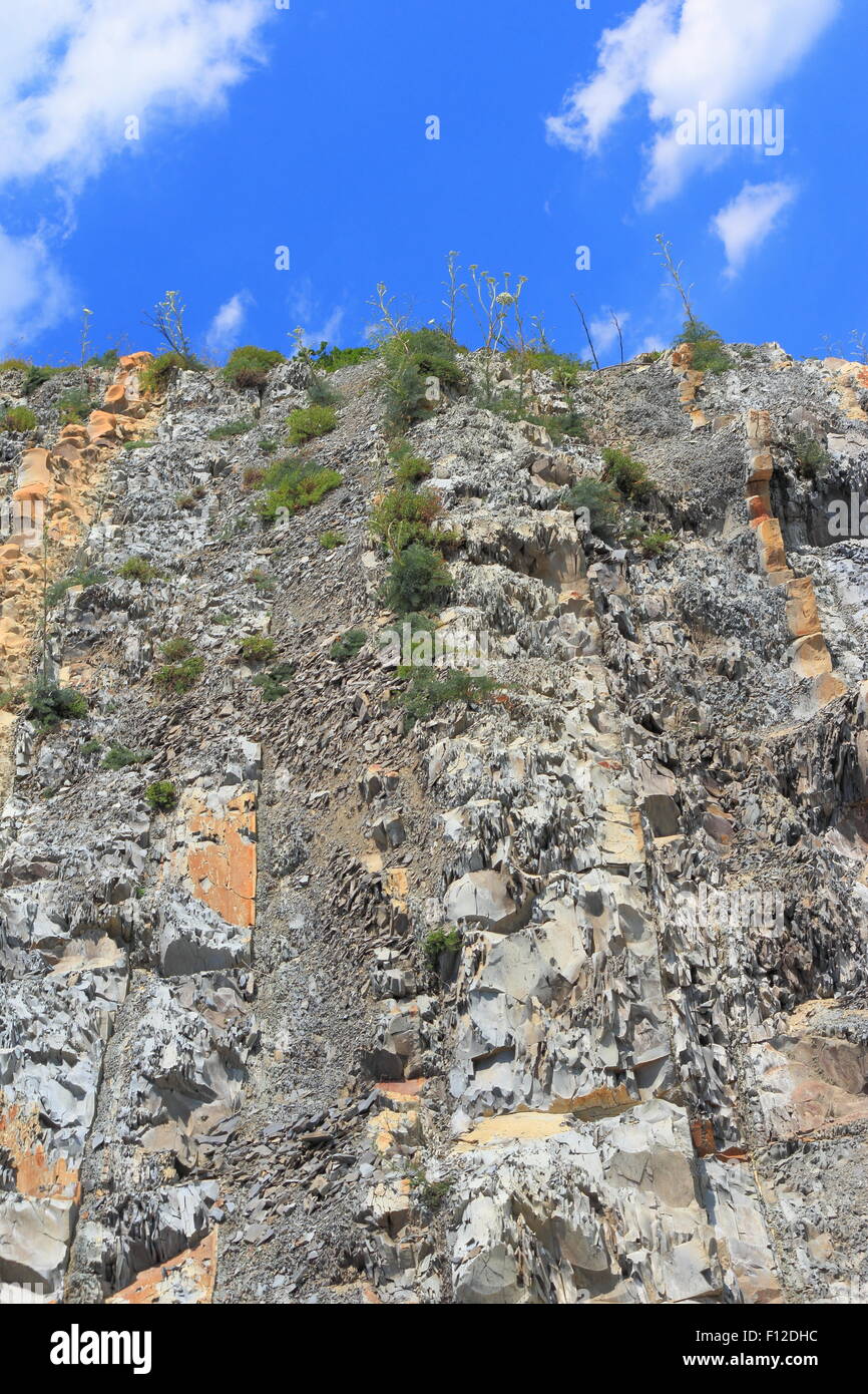 Coastal steep mountain slope with visible rock strata with a background of the sky Stock Photo