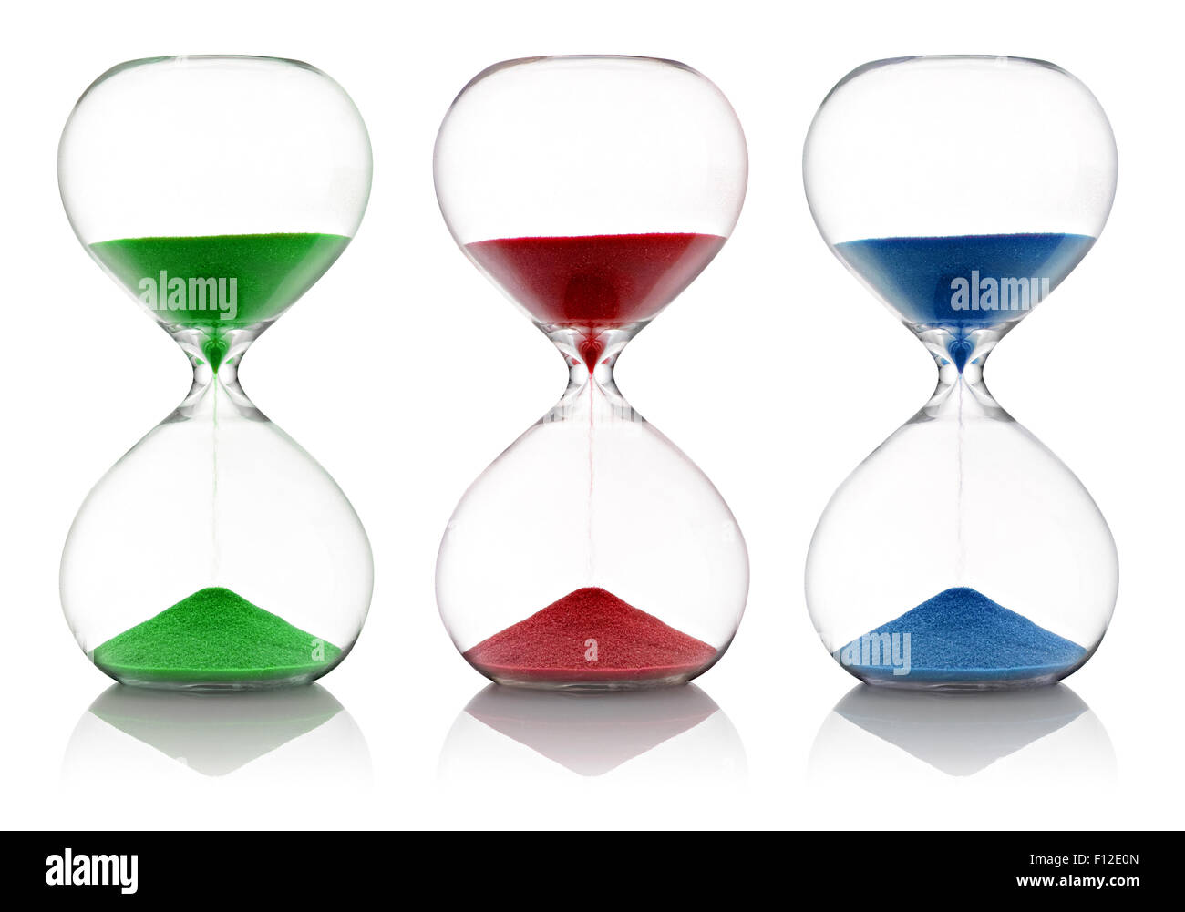 Colored sand, red, green and blue, running through glass hourglasses Stock Photo