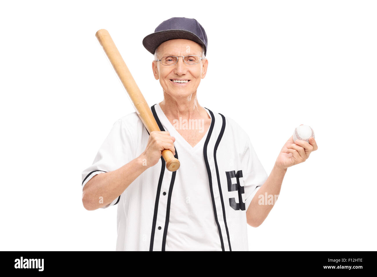 Active senior in baseball jersey holding a baseball bat and a ball isolated on white background Stock Photo