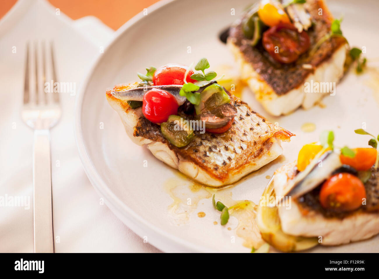 striped bass with cherry tomatoes, olives and anchovy, Tydes Restaurant, Coral Casino, Biltmore Hotel, Santa Barbara, California Stock Photo