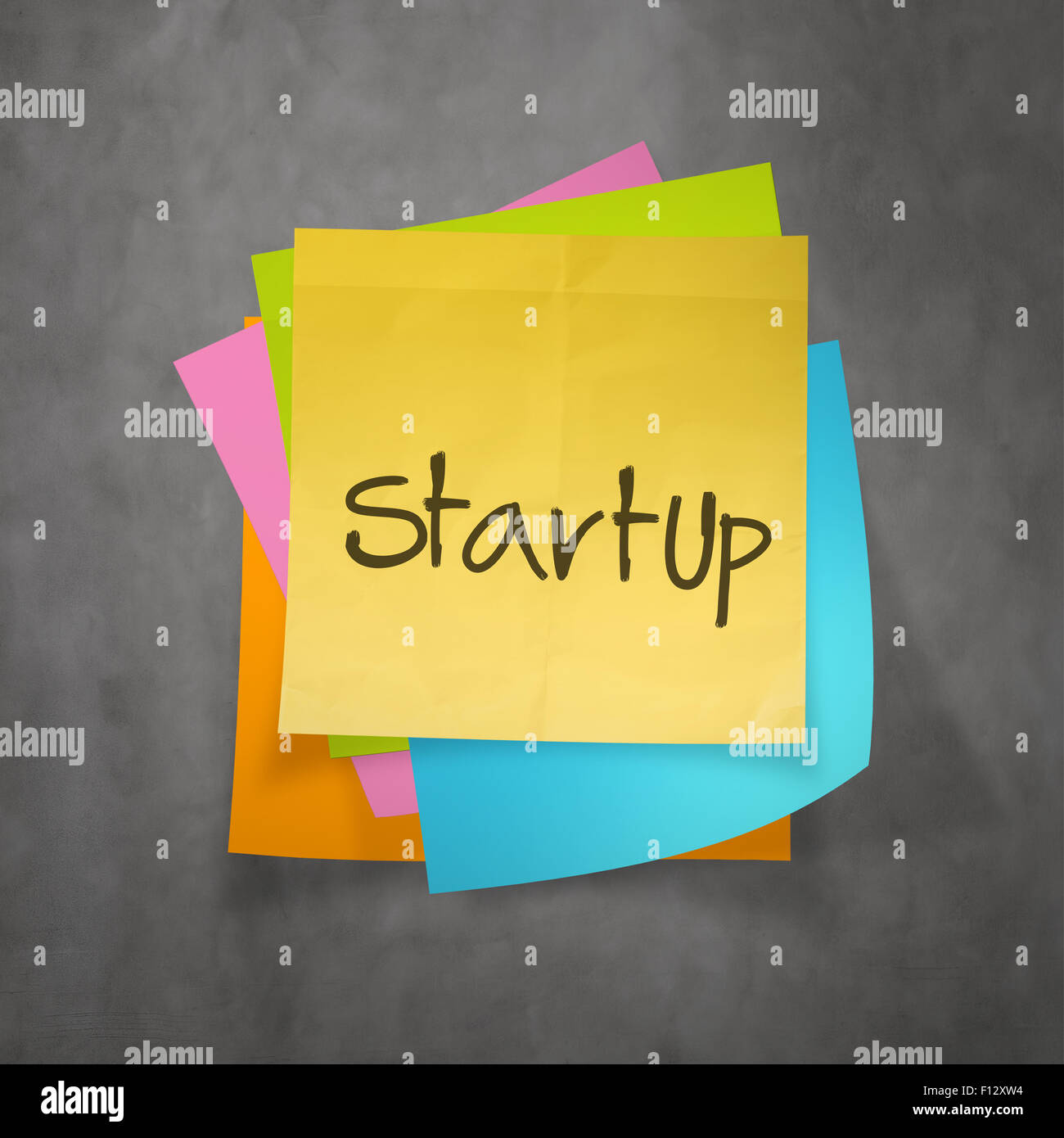hand writing Startup business concept on sticky note paper Stock Photo