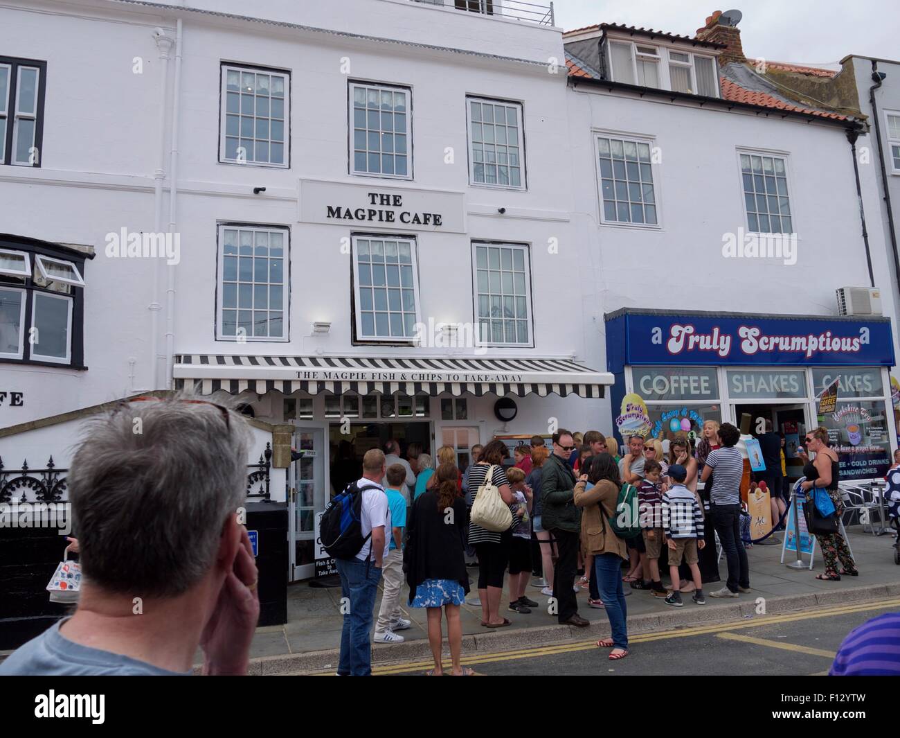 People queuing outside the famous Magpie Cafe for fish and chips in Whitby. Stock Photo