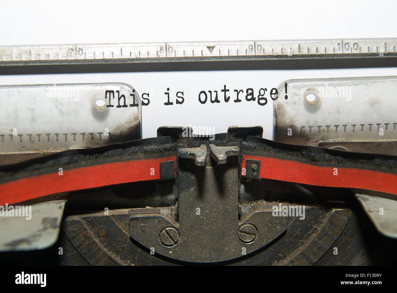 Sheet of paper with the inscription 'This is outrage''  in the typewriter Stock Photo