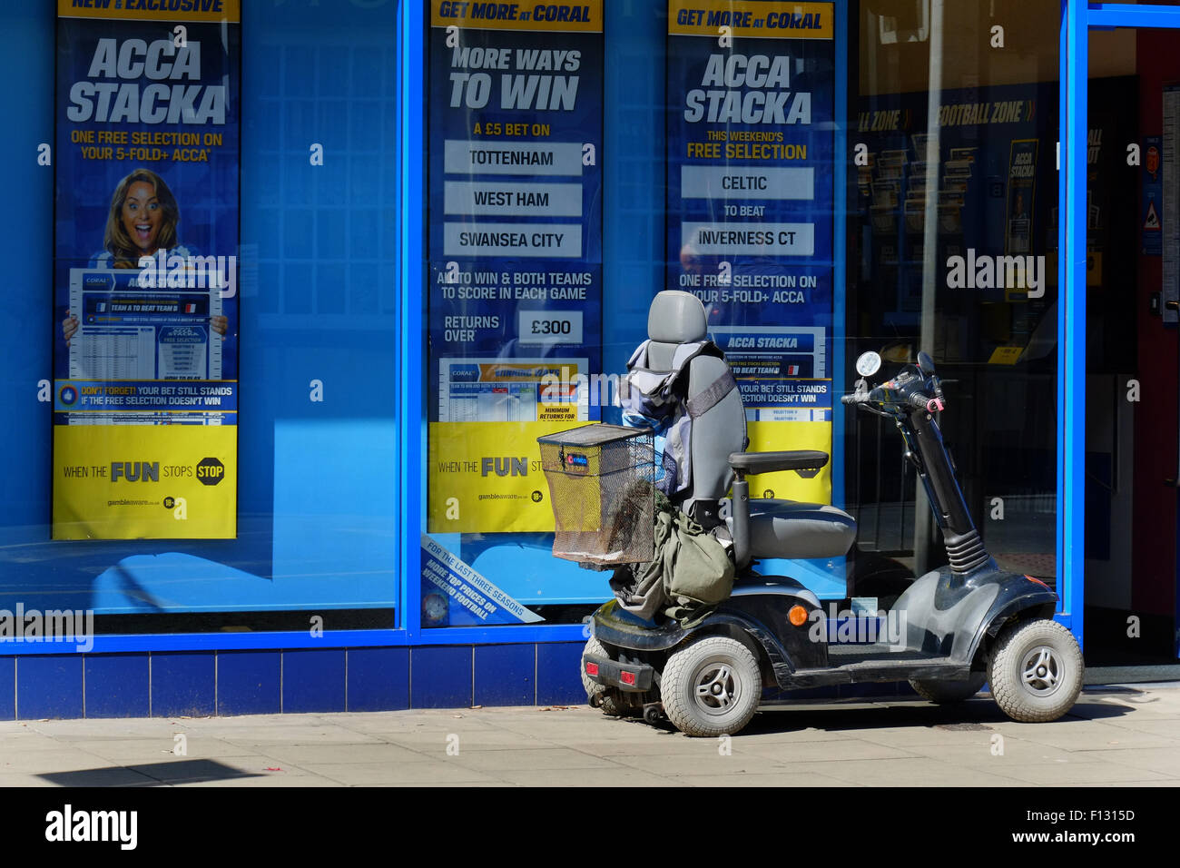 Invalid electric vehicle outside betting shop. Stock Photo