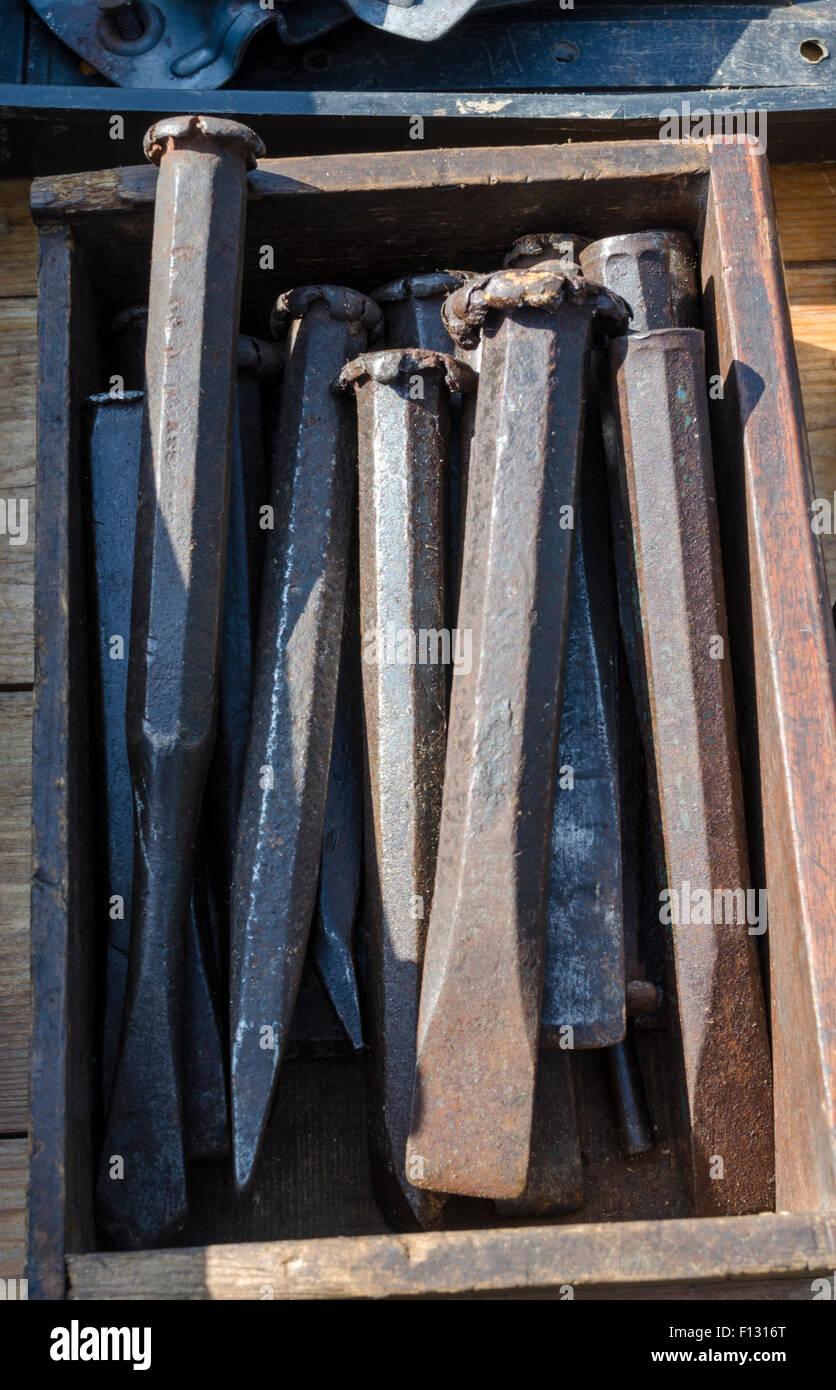 A selection of old cold chisels in a wooden box at a car boot sale Stock Photo