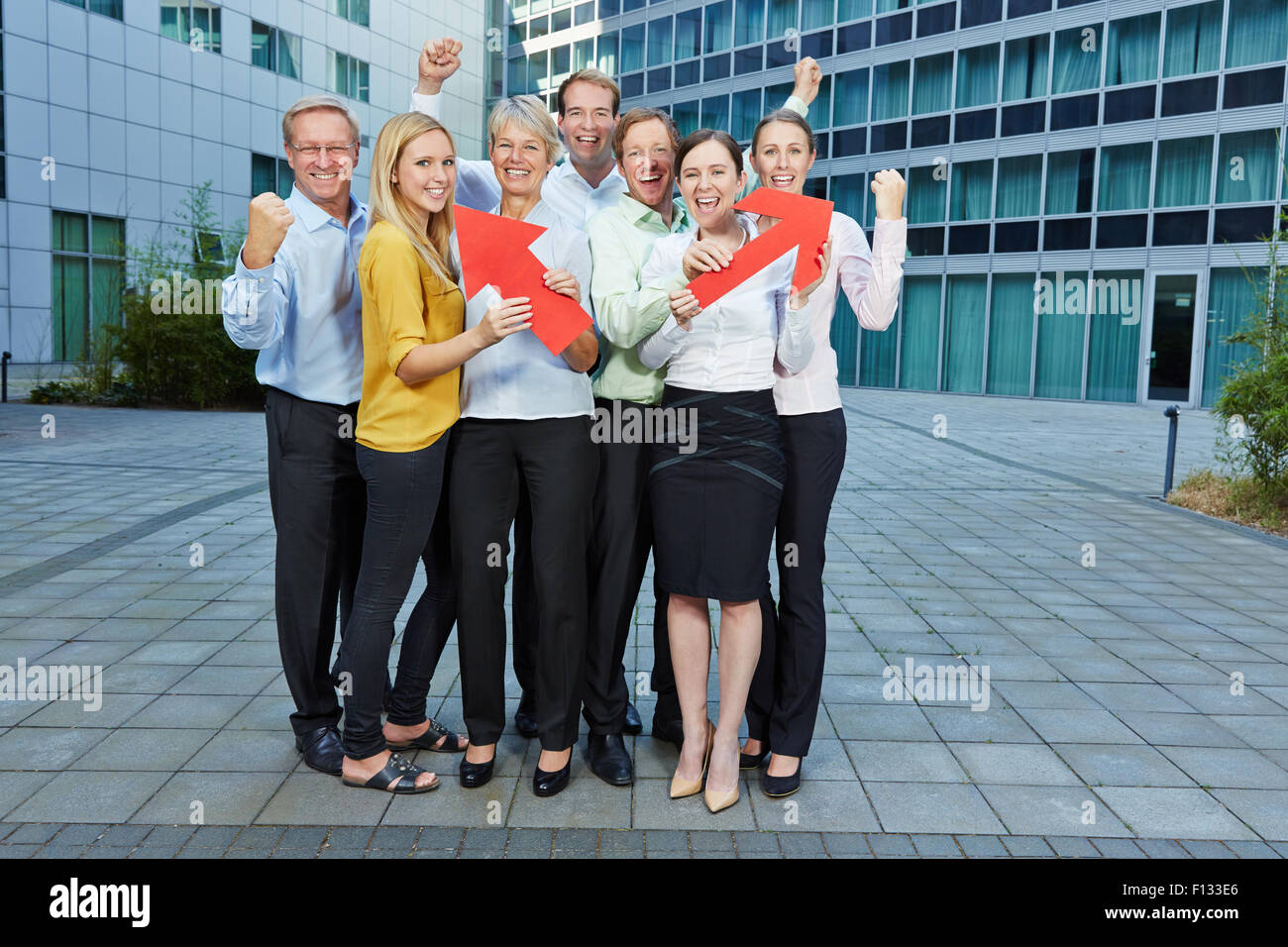 Cheering business people team with red arrows pointing up Stock Photo
