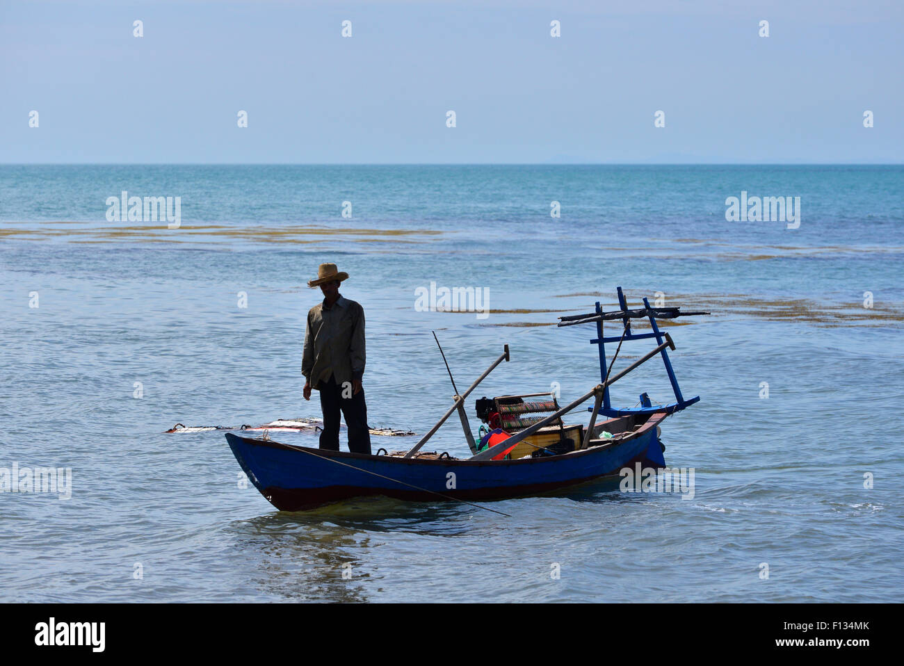Silhouette of a fisherman standing on a boat Stock Photo - Alamy