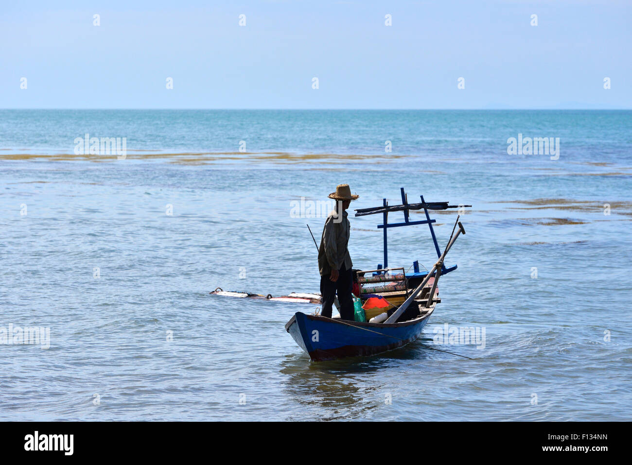 Silhouette of a fisherman standing on a boat Stock Photo - Alamy