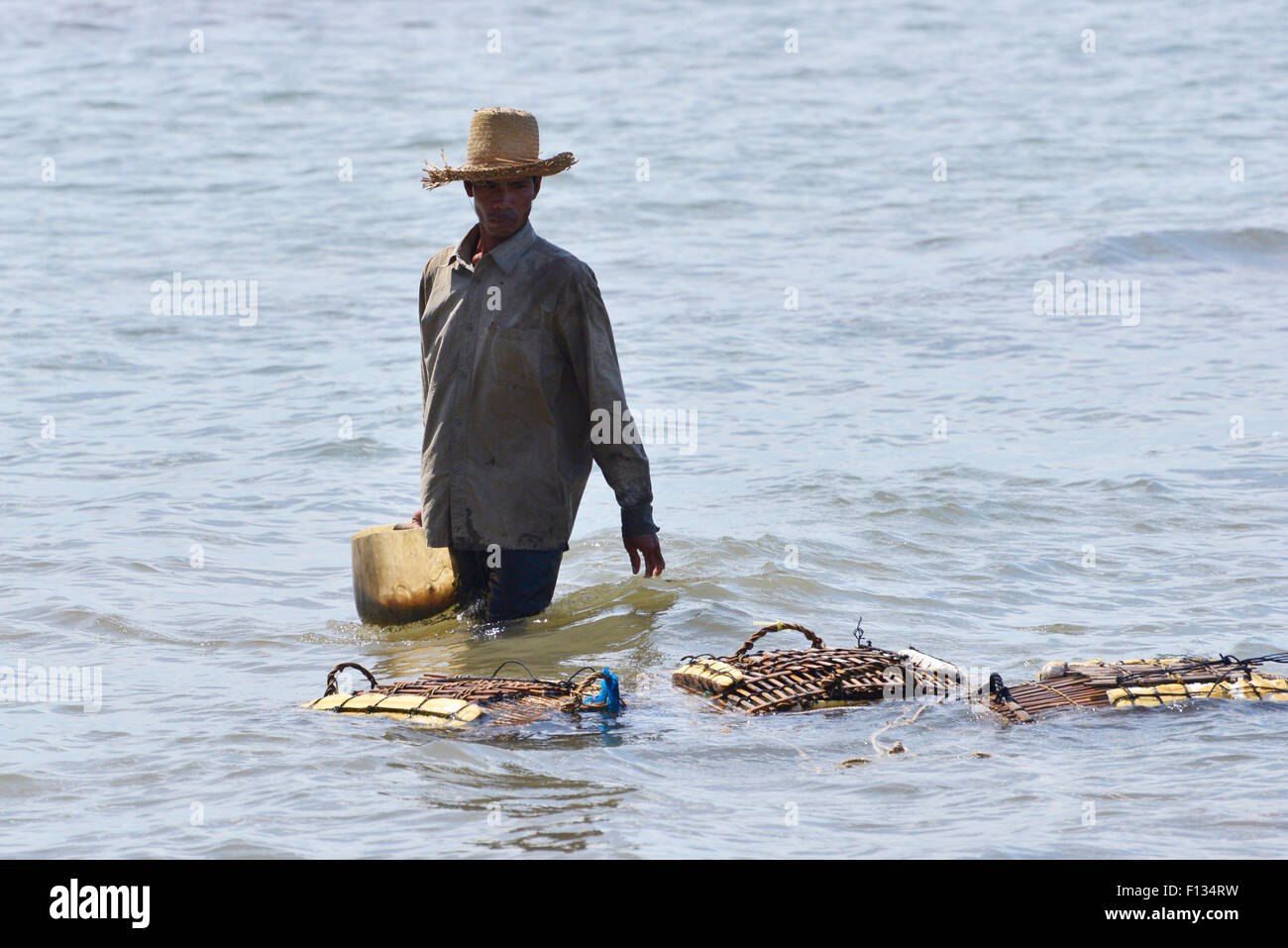 Crab fisherman walking in the water Stock Photo