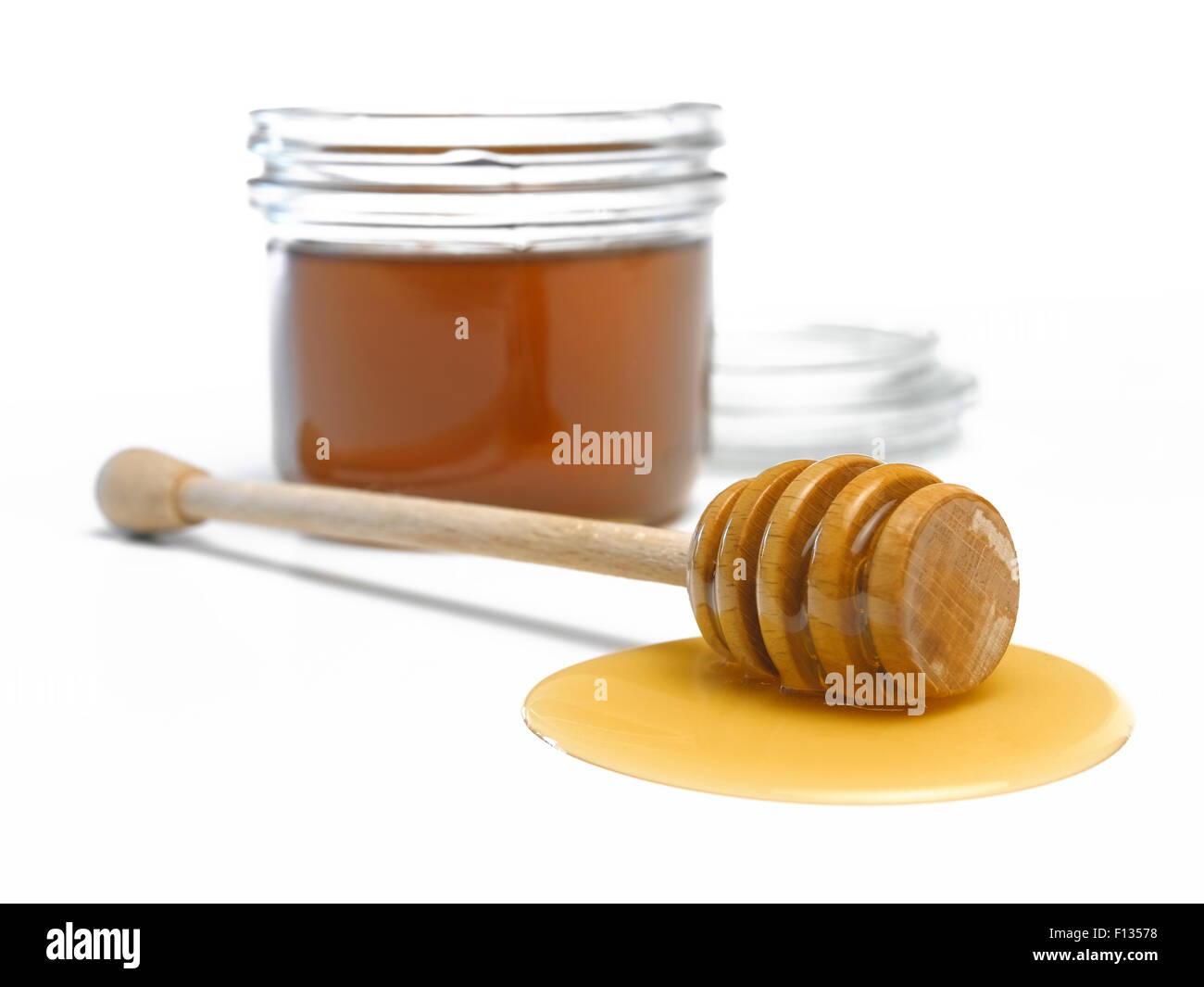 Honey dipper with ajar filled with honey Stock Photo