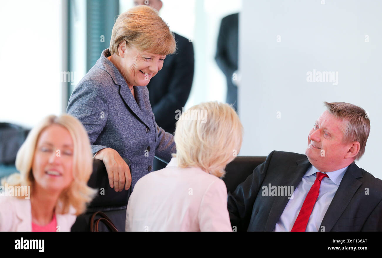 Berlin, Germany. 26th Aug, 2015. German Chancellor Angela Merkel (CDU, C, back) talks to German Minister of Family Affairs Manuela Schwesig (SPD, L), German Defence Minister Ursula von der Leyen (CDU, C, front, back view) and German Health Minister Hermann Groehe (CDU, R) prior to a German government cabinet meeting at the chancellery in Berlin, Germany, 26 August 2015. Photo: Kay Nietfeld/dpa/Alamy Live News Stock Photo