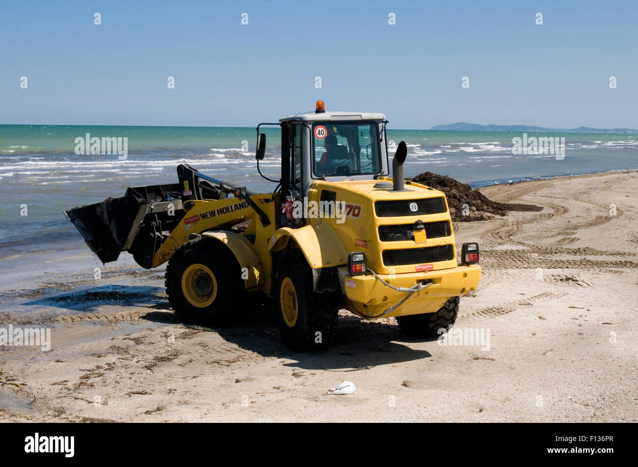 new holland digger diggers earth mover movers excavator earthmovers earthmover big yellow dig digging an hole bucket excavators Stock Photo