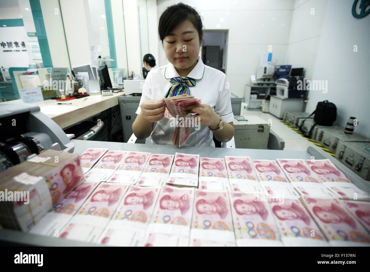 A worker counts Chinese currency Renminbi (RMB) at a bank in Hauibei, east China's Anhui Province, Aug 26, 2015. China's yuan fe Stock Photo
