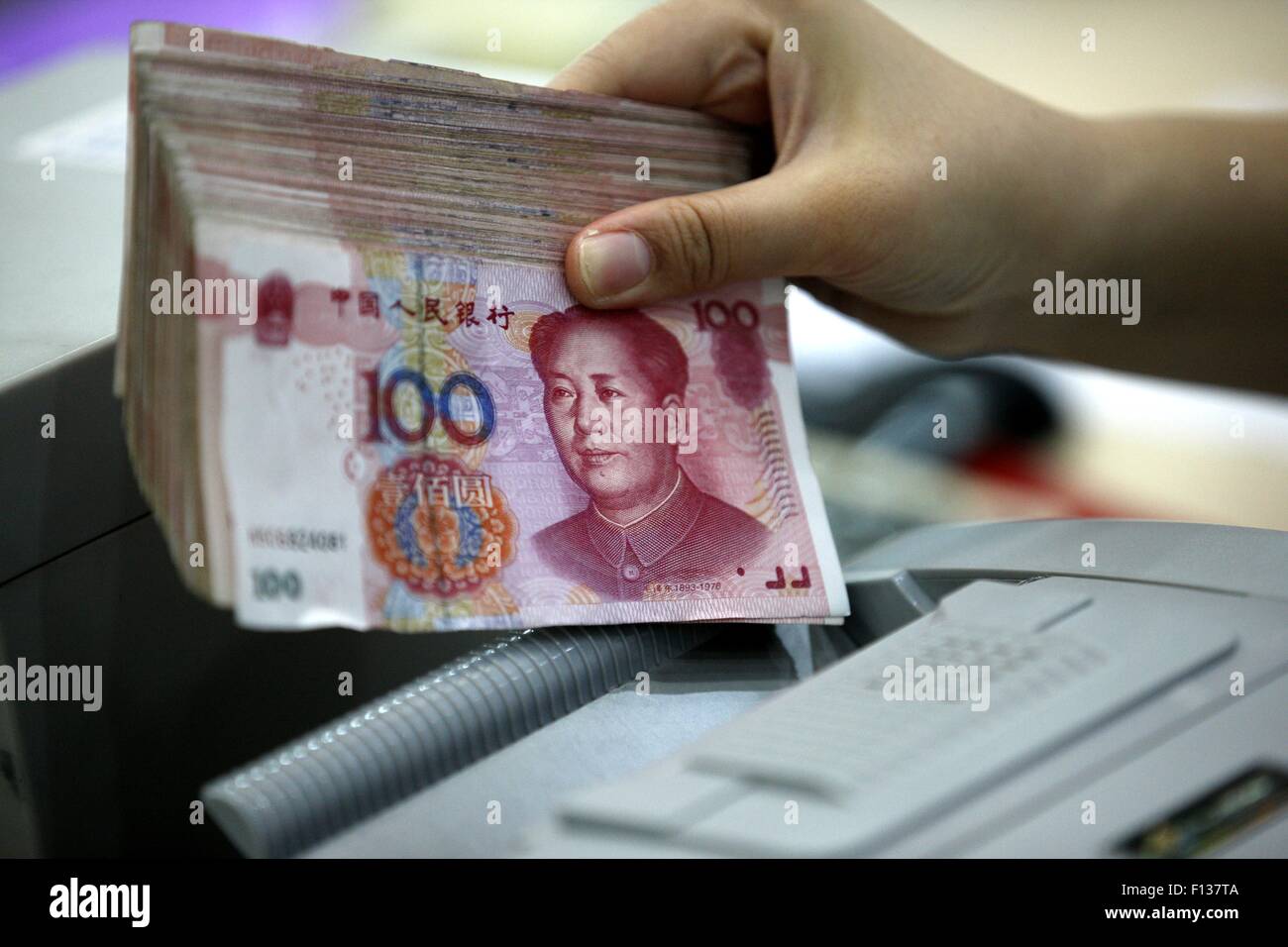 A worker counts Chinese currency Renminbi (RMB) at a bank in Hauibei, east China's Anhui Province, Aug 26, 2015. China's yuan fe Stock Photo