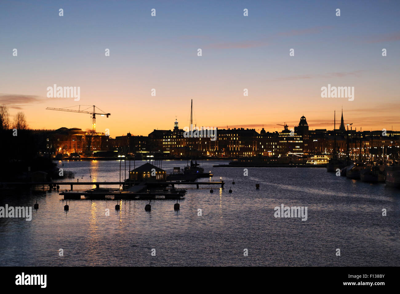 Dusk by the waterfront at Nybroviken in Stockholm, Sweden. The lights of city shine in the dusk. Stock Photo
