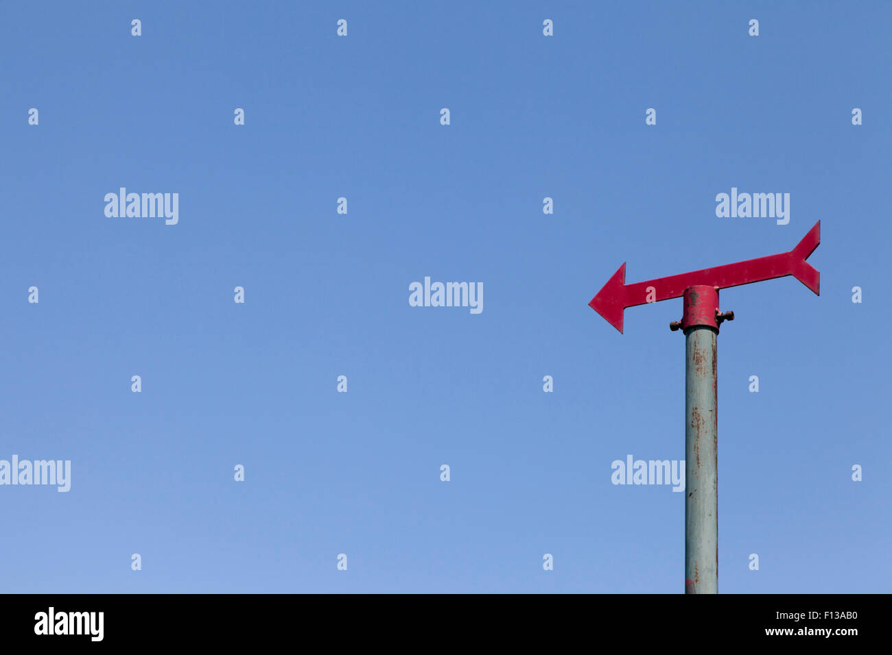 Red signpost against clear blue sky Stock Photo