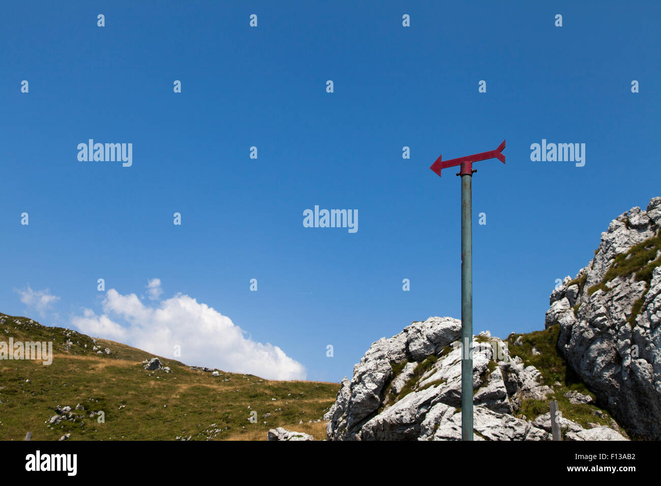 Red signpost in the mountains Red signpost in the mountains against cloudy blue sky Stock Photo
