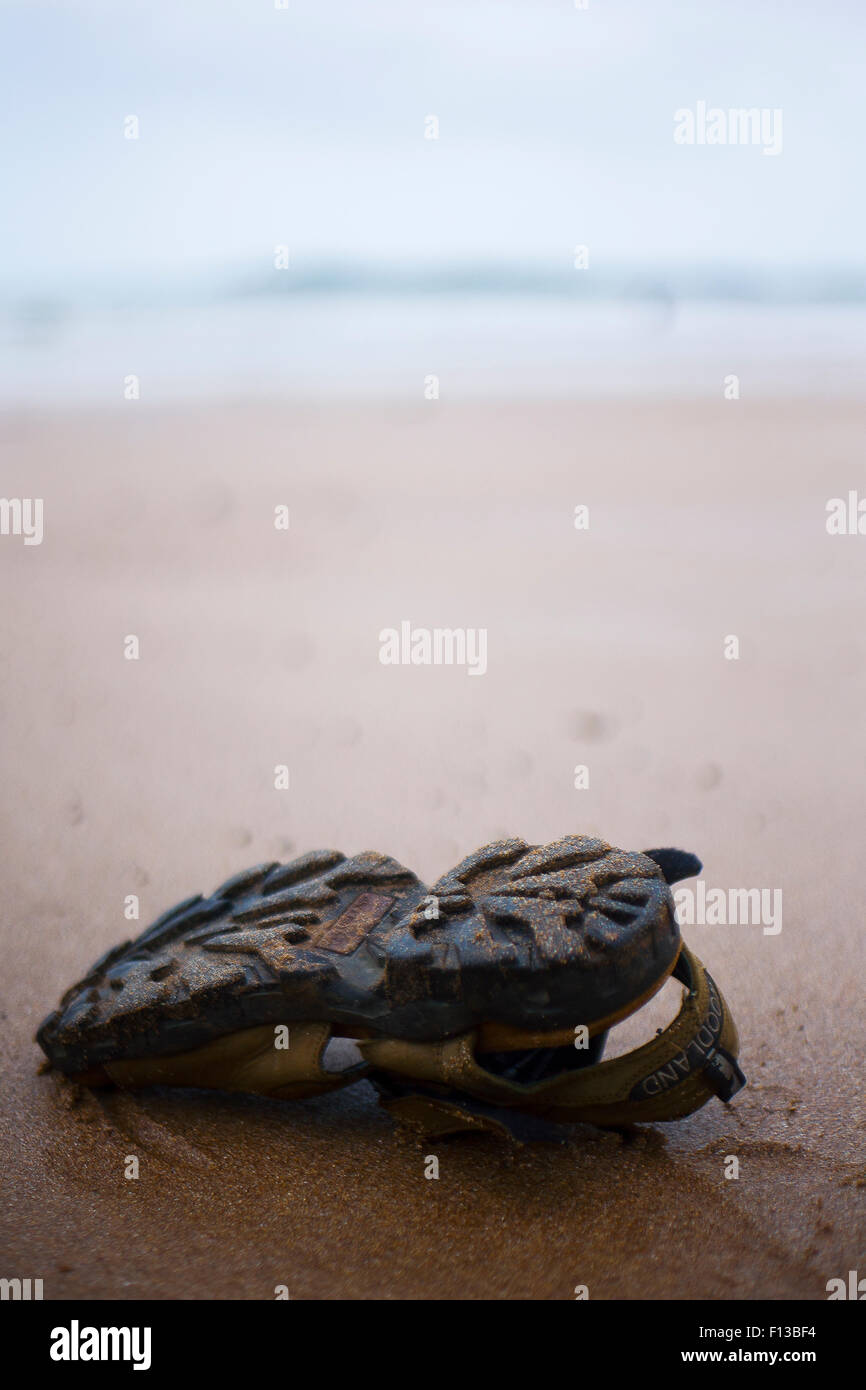 Footprints and Sandals on the beach Stock Photo