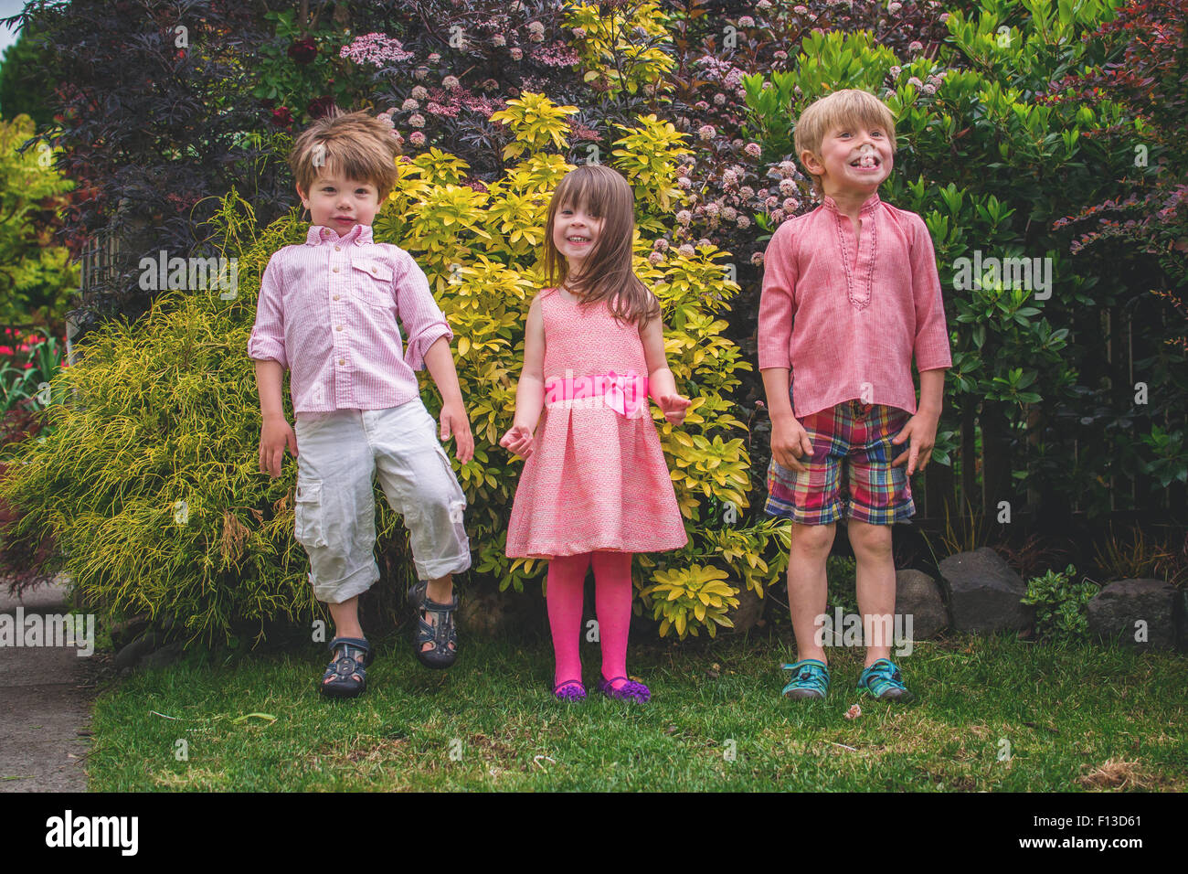 Three children standing in a row Stock Photo