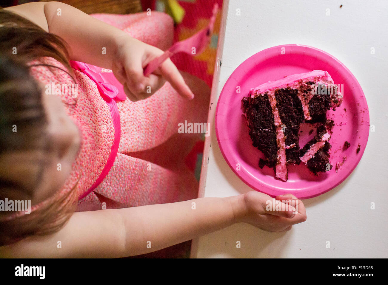 Overhead view of girl sitting at a table eating a slice of chocolatecake Stock Photo
