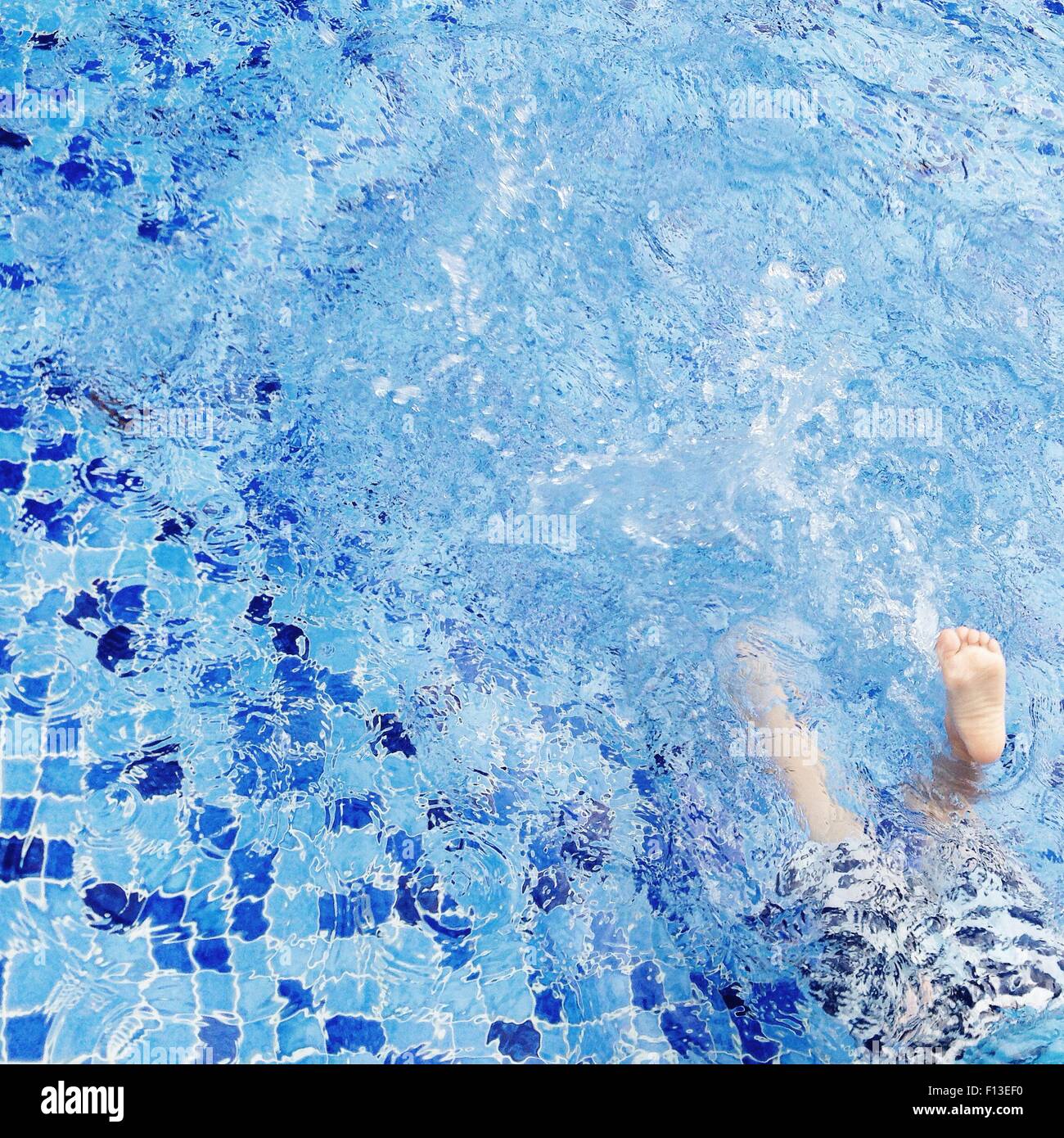 Boy splashing in swimming pool Stock Photo