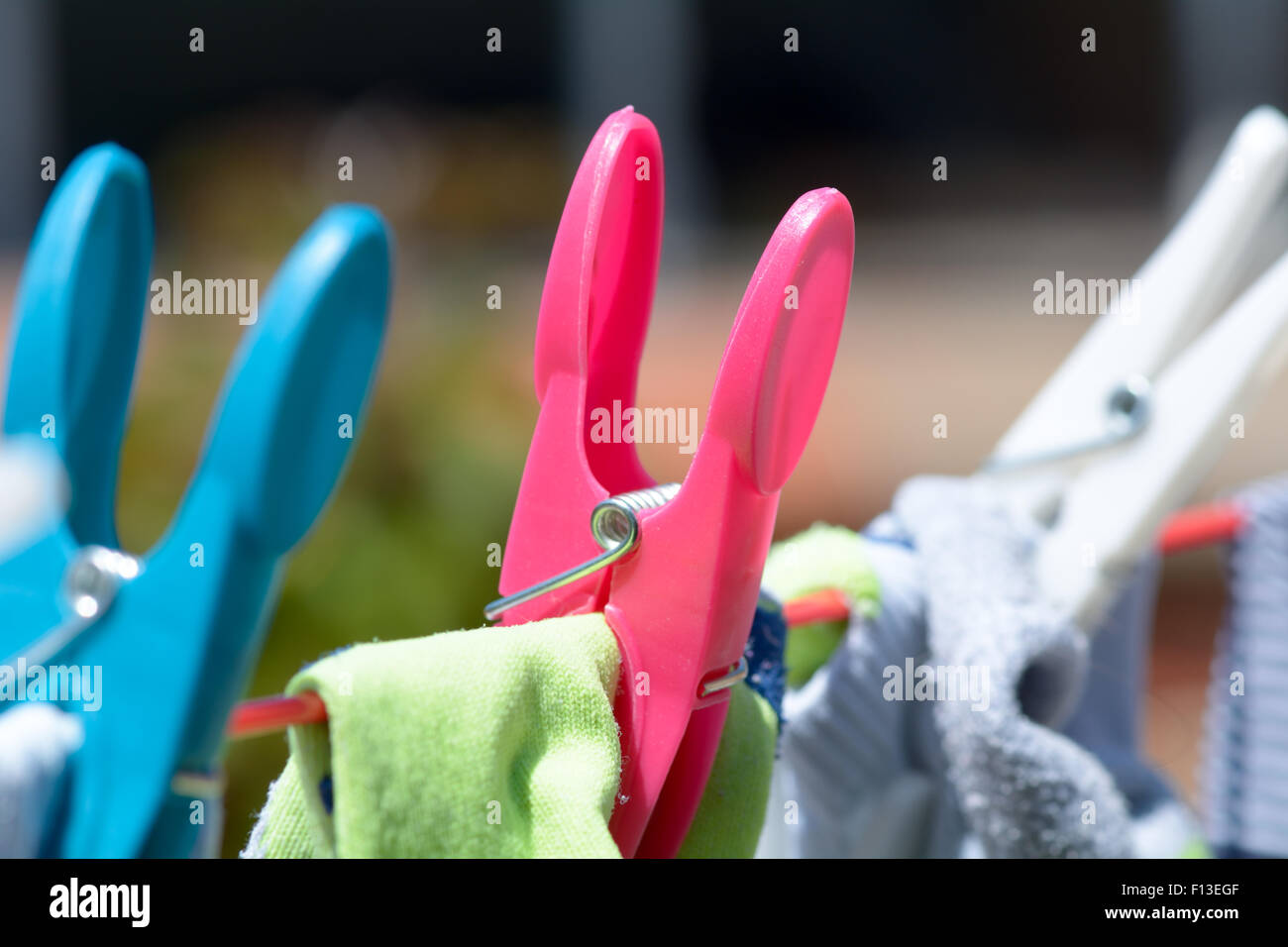 Clothes pegs and clothes drying on washing line in garden Stock Photo