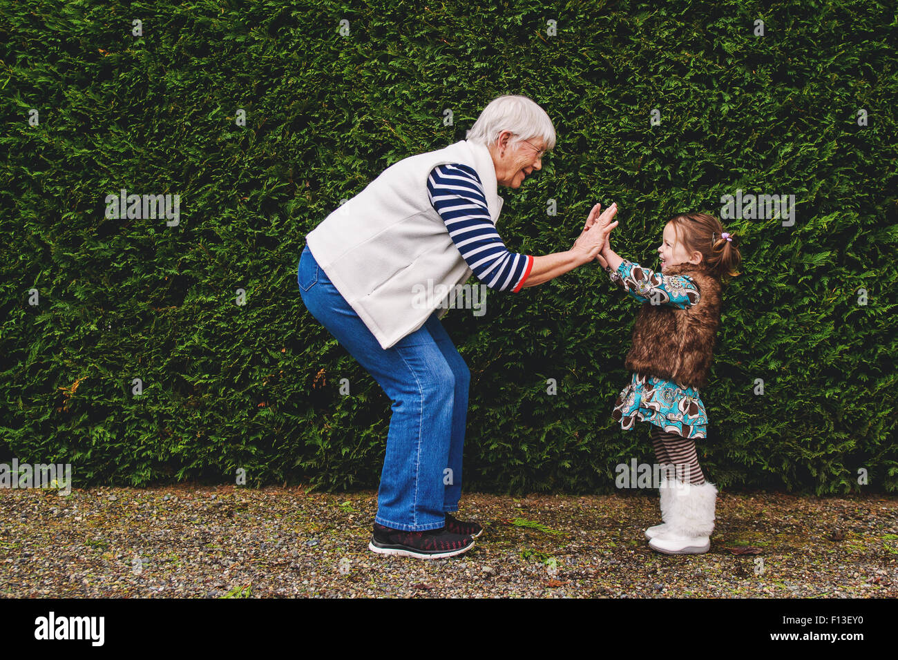 Girl playing pat-a-cake with her grandmother Stock Photo