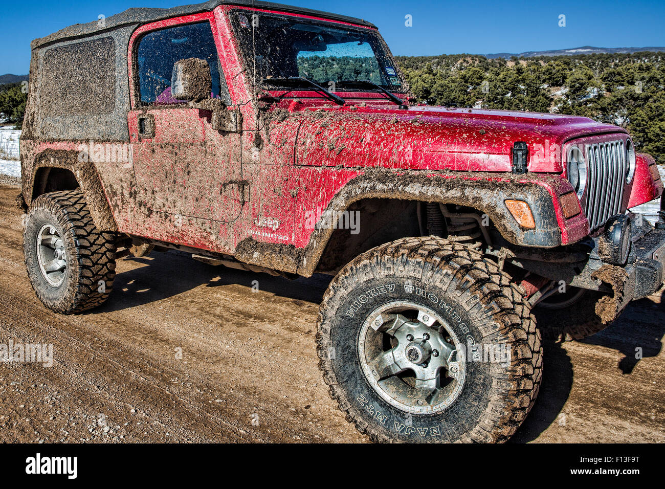 Muddy Jeep Unlimited with Mickey Thompson Baja MTZ tires on muddy Colorado Trail Stock Photo