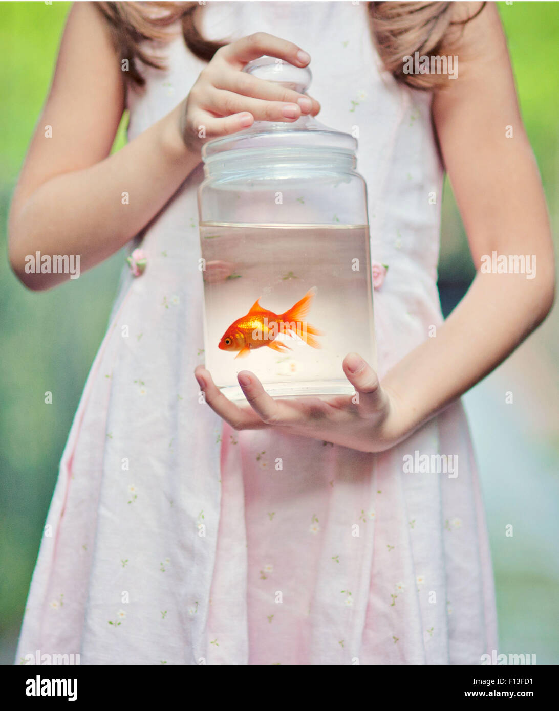 Girl holding a Goldfish in a jar Stock Photo