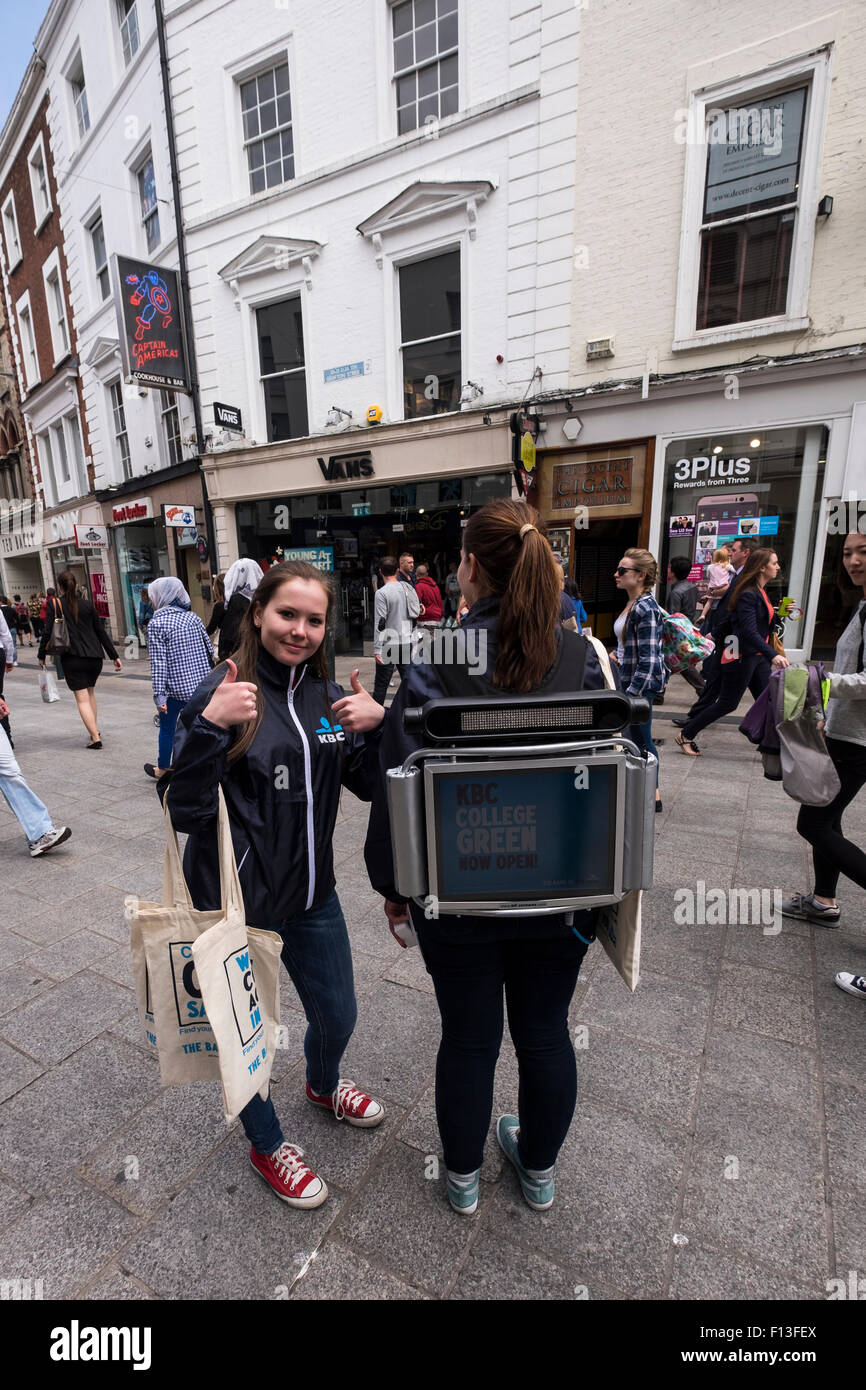 Two pr girls with a space age monitor strapped to her back and distributing gifts to passersby in Grafton Street to promote the Stock Photo