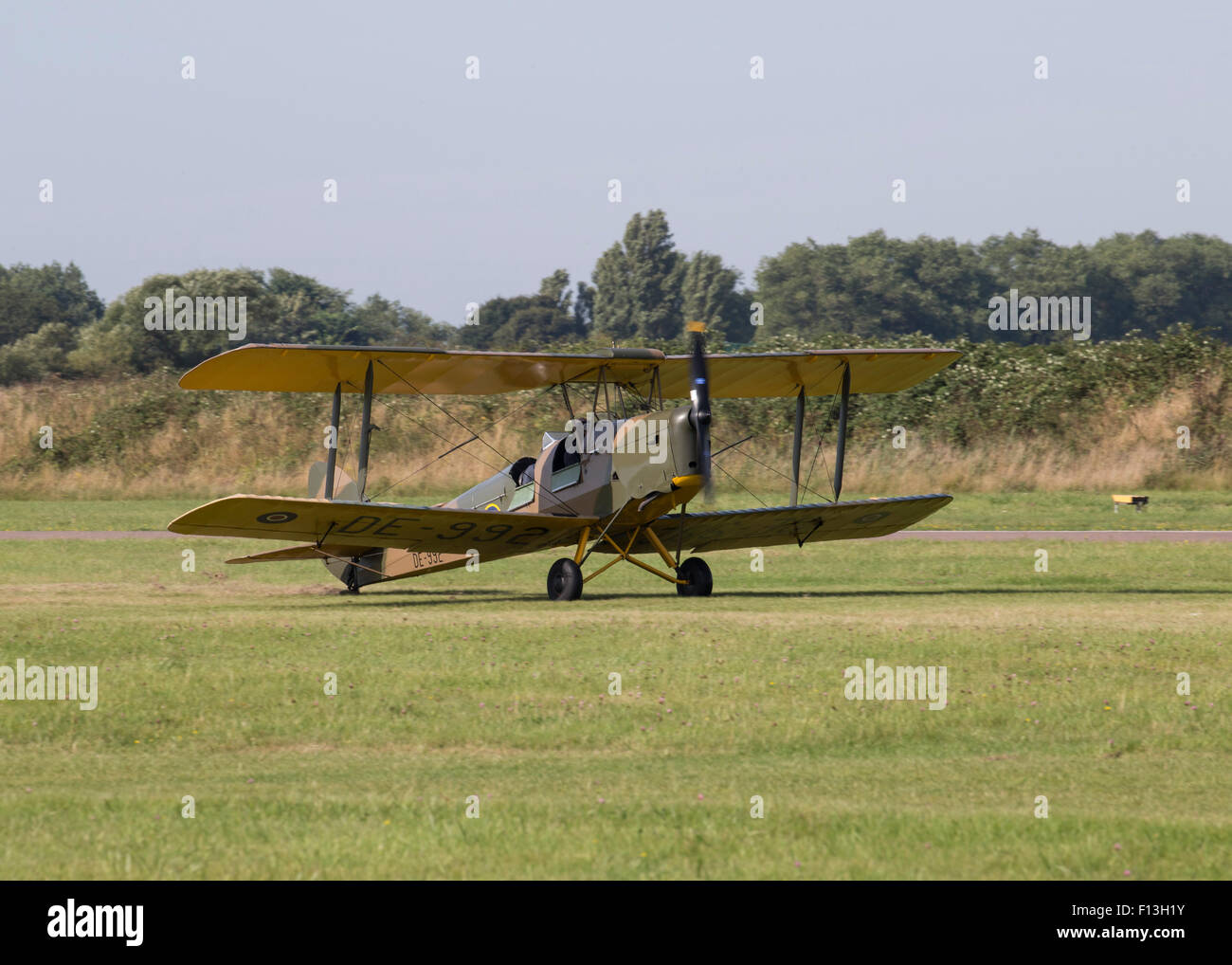 A Tiger Moth biplane aircraft in RAF wartime camouflage livery flying ...