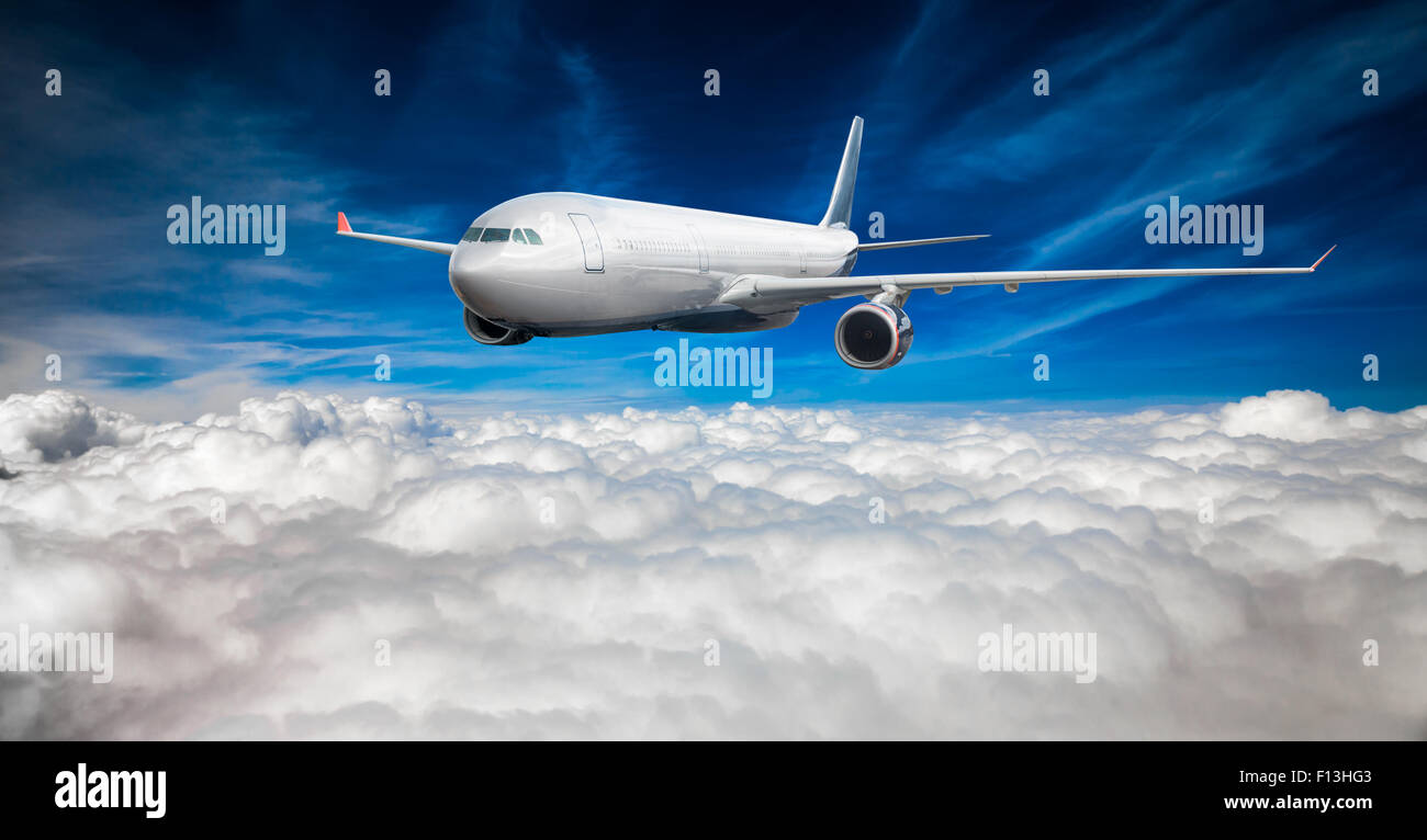 Passenger Airliner flying in the clouds Stock Photo