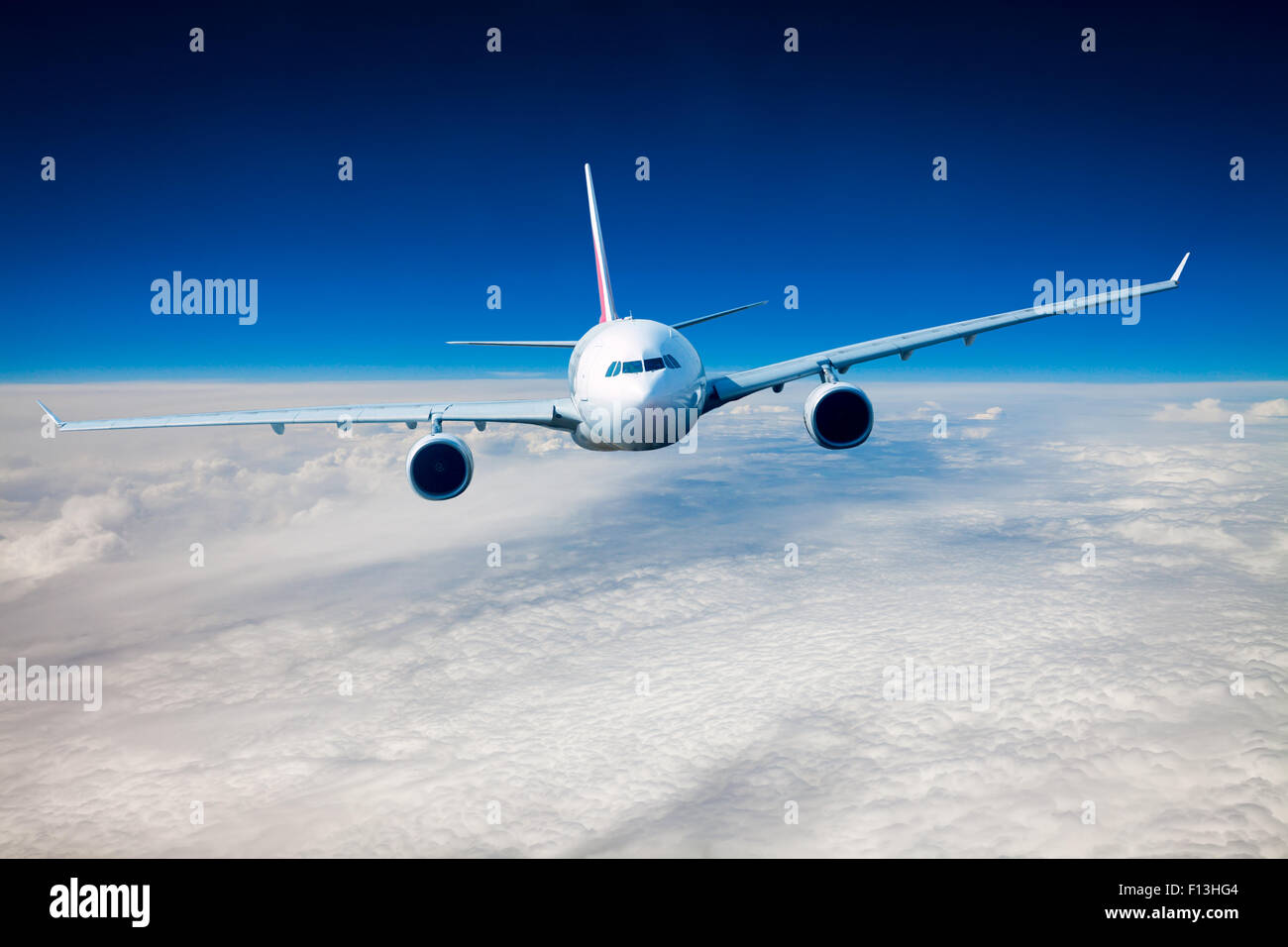 Passenger Airliner flying in the clouds Stock Photo