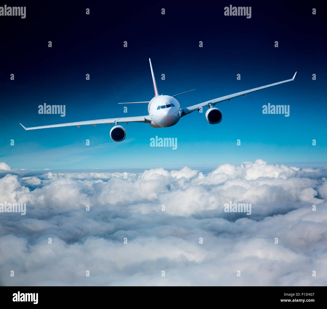 Passenger Airliner flying in the clouds Stock Photo