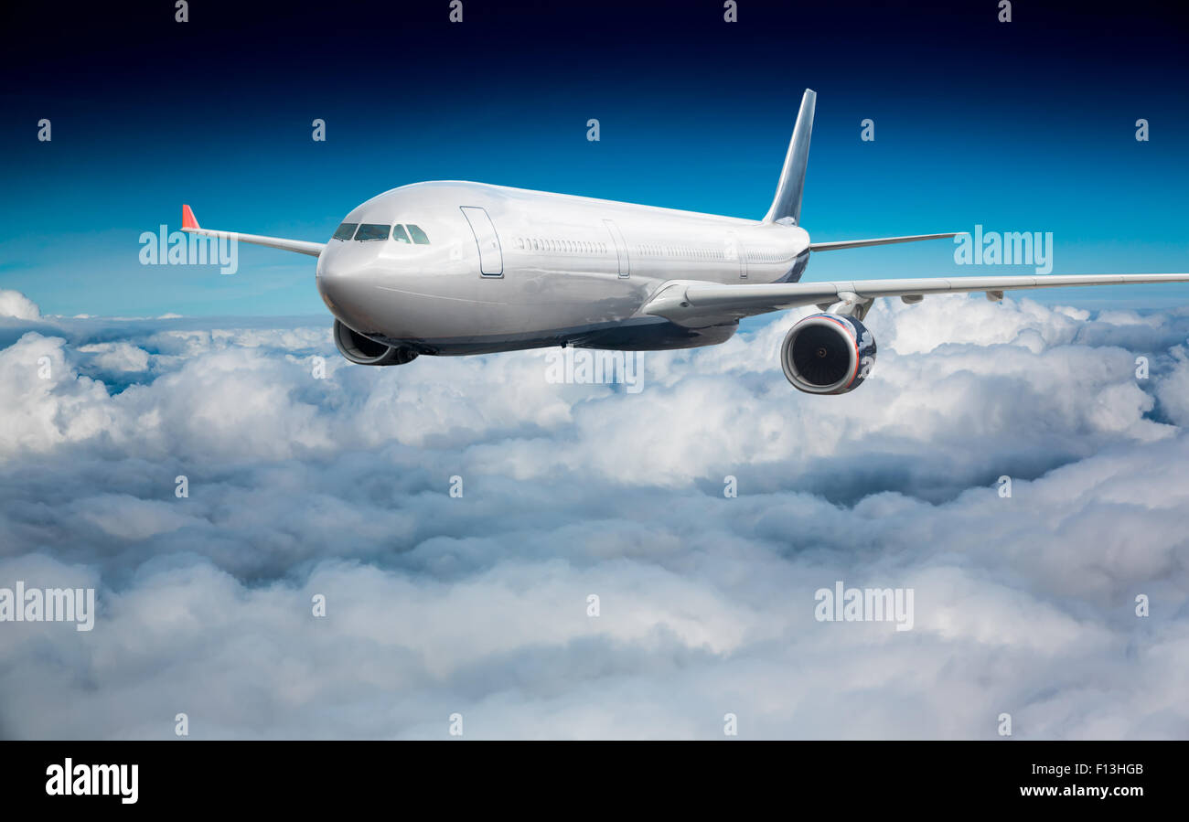 Passenger Airliner flying in the clouds Stock Photo