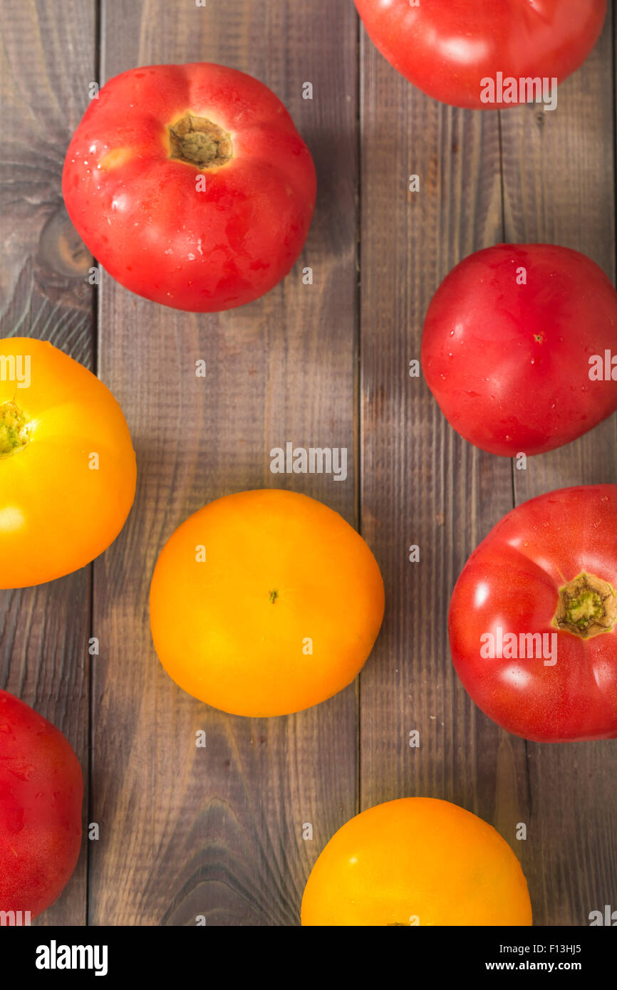 Fresh big red and yellow tomatoes on wooden background top view Stock ...