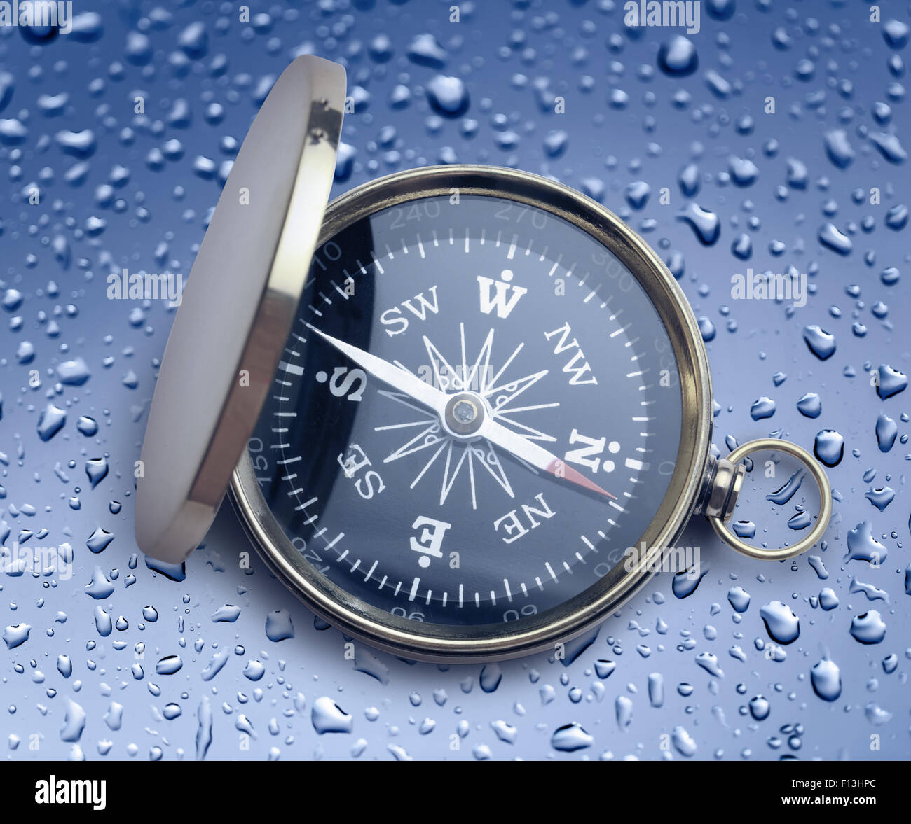 Golden vintage compass opened on raindrop background Stock Photo - Alamy