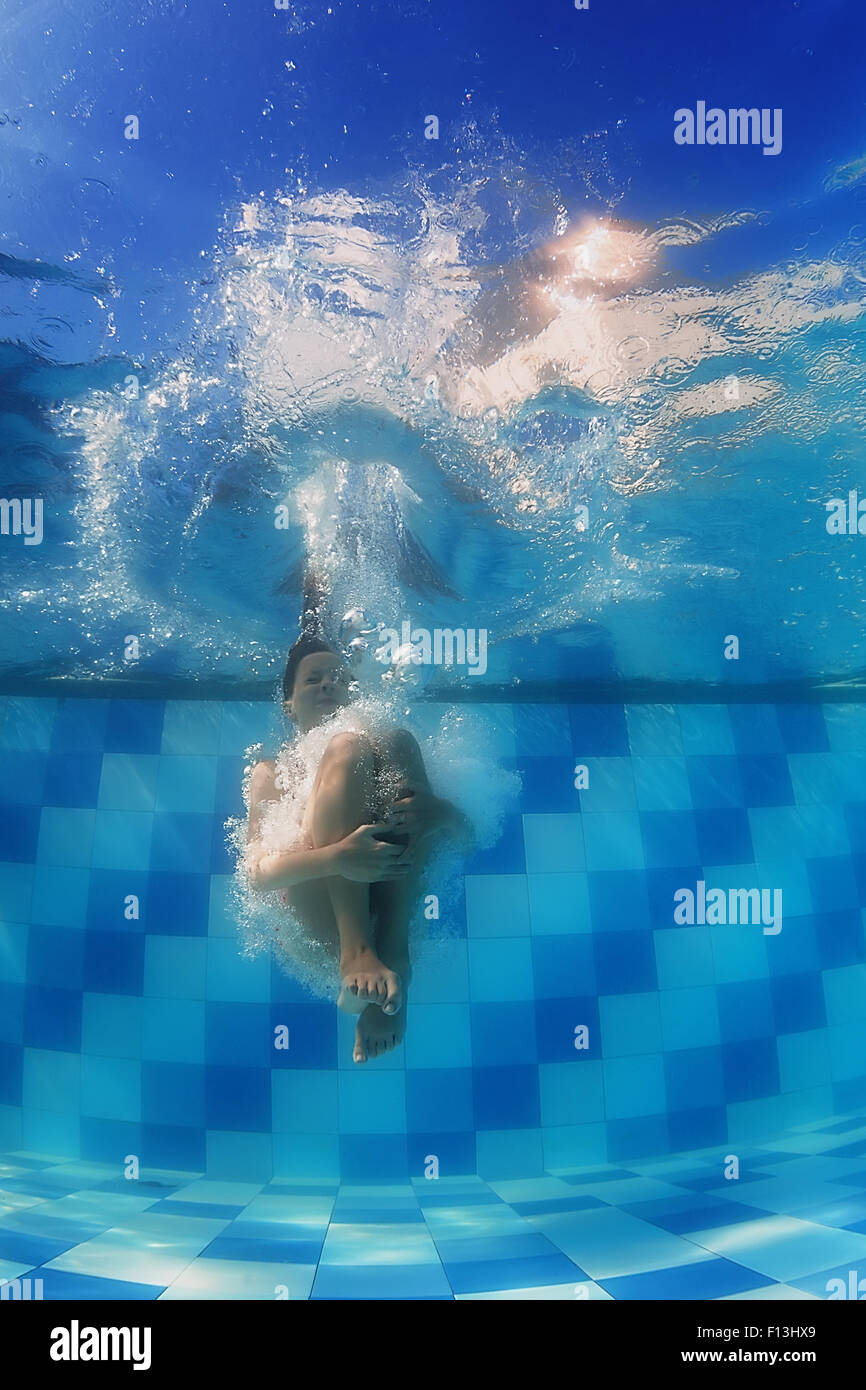 Happy child swimming, diving in pool with fun jump deep down