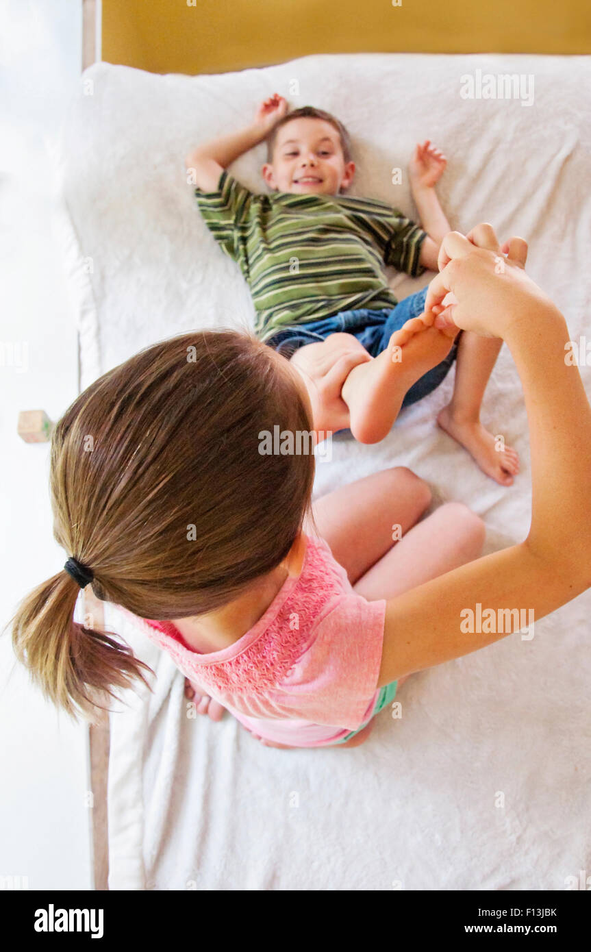 girl tickling toes of boy Stock Photo
