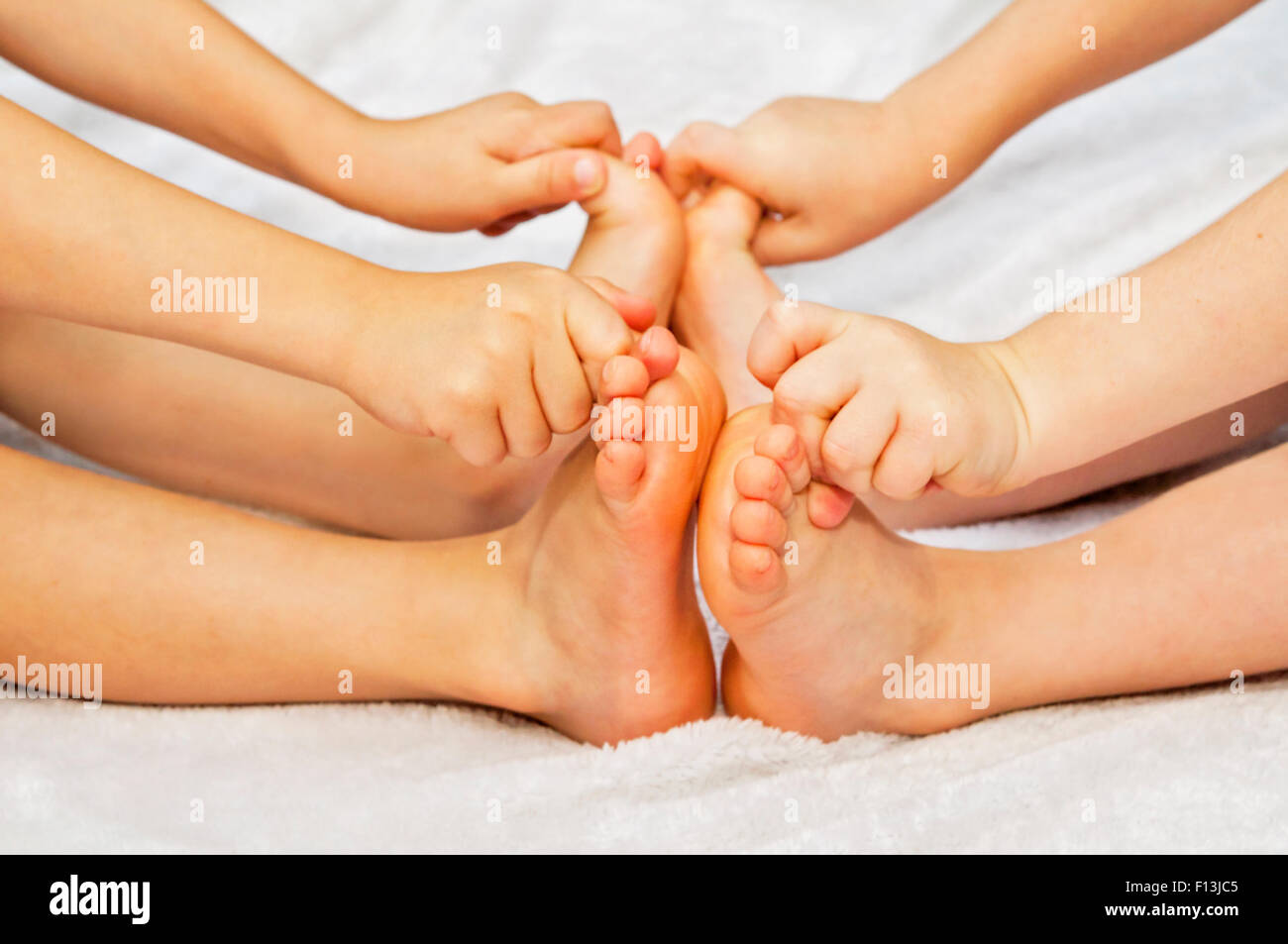 two little kids grabbing toes on their barefeet Stock Photo