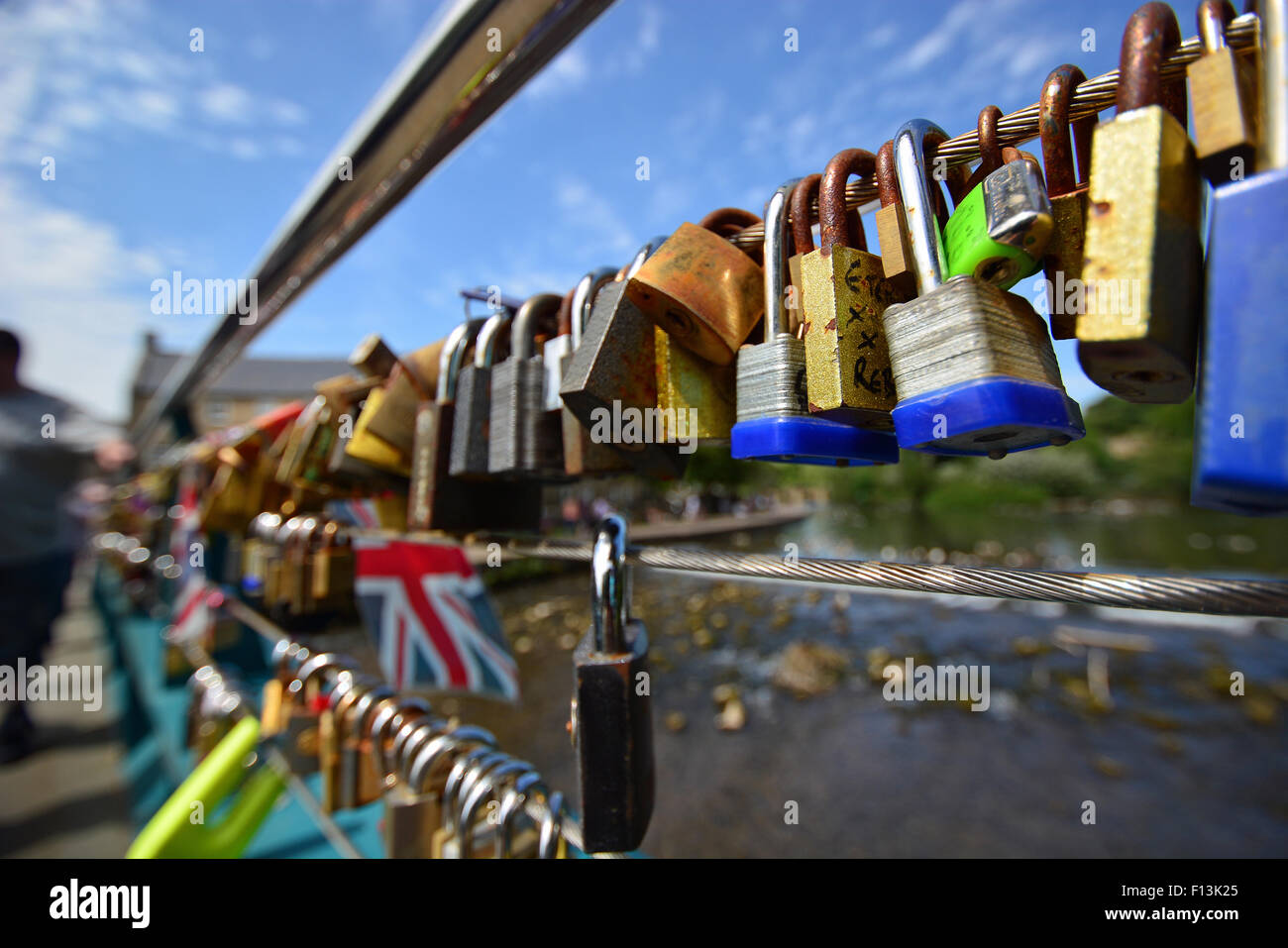 Colourful padlocks inscribed with lovers initials attached to a bridge